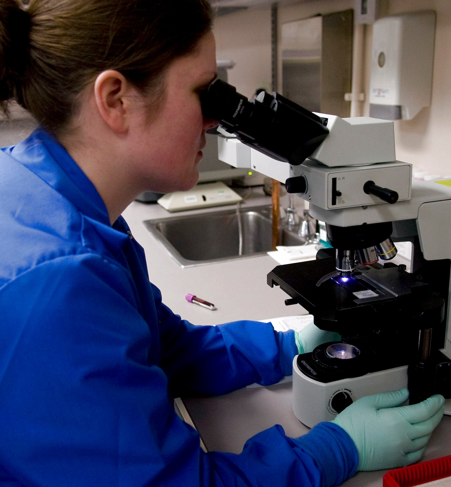 Staff Sgt. Toni Thompson looks into a microscope, viewing red and white blood cells magnified at 100 times their original size March 4 at Eielson Air Force Base, Alaska. The purpose of the examination is to ensure the blood contains no disease or infection. Sergeant Thompson is a 354th Medical Group clinical lab technician. (U.S. Air Force photo/Airman 1st Class Laura Max) 
