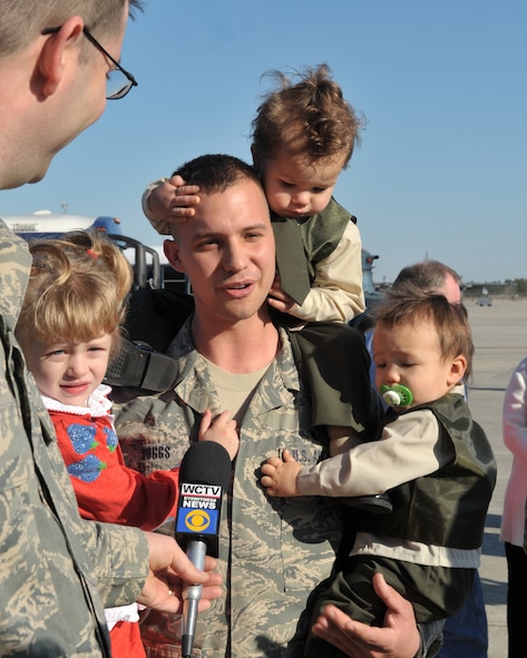 MOODY AIR FORCE BASE, Ga. -- Staff Sgt. Gregory R. Boggs, 723rd Aircraft Maintenance Squadron, weapons maintainer, along with his children, (right to left) Parker, Austin and Amaris, are interviewed by a local news reporter upon his return home after a three month deployment to Balad Air Base, Iraq, here March 6. He was one of approximately 100 Airmen who was deployed in support of Operation Iraqi Freedom. (U.S. Air Force photo by Senior Airman Javier Cruz Jr)