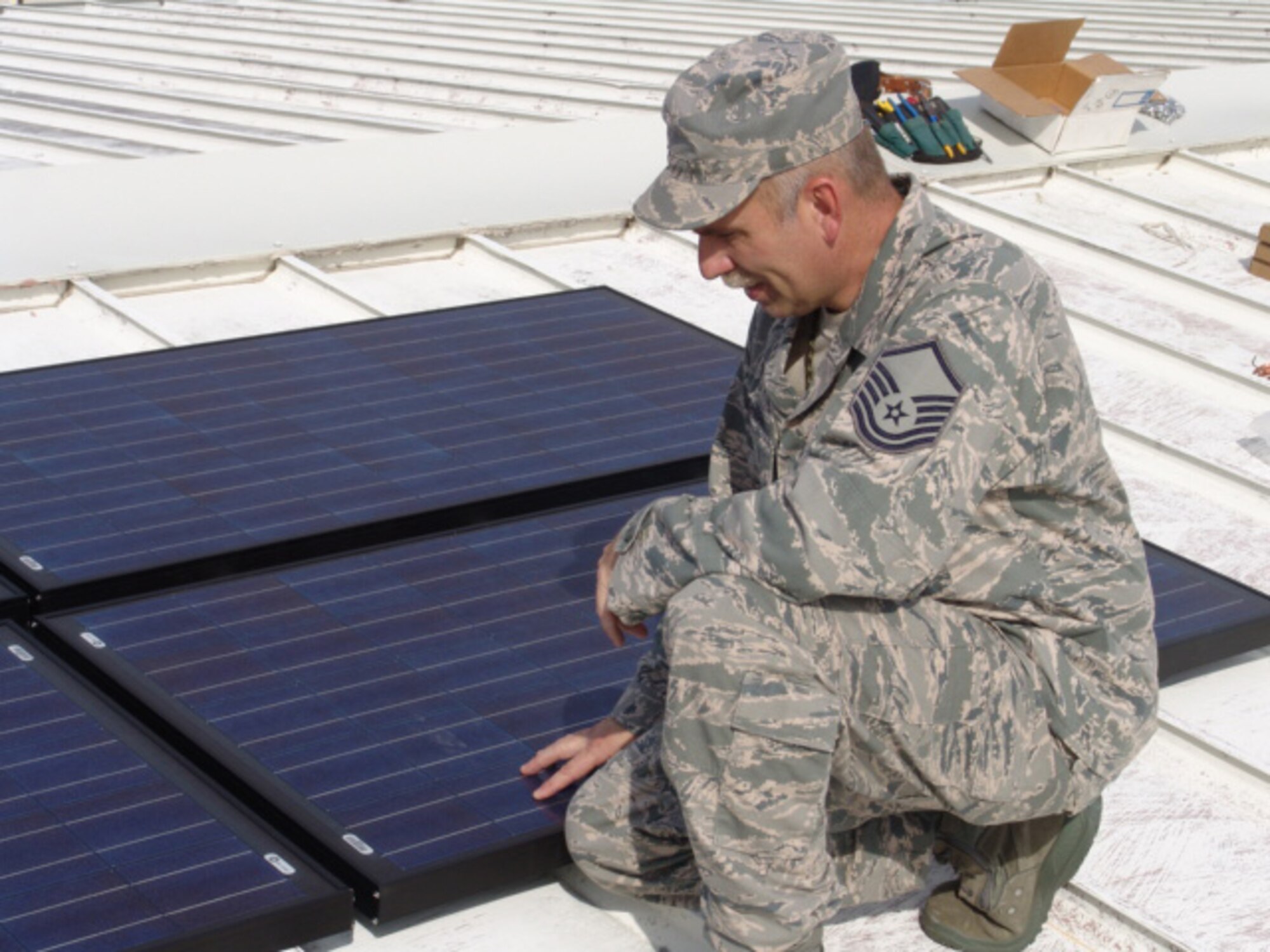EGLIN AIR FORCE BASE, Fla. -- Master Sgt. Mark Baughman, 46 Aircraft Maintenance RED Support Section Chief, examines a solar panel on top of of the Squadron's Hangar 102. His unfunded request of $25,000 paid for10 panels that are expected to generate 50 percent of the hangar's power and save nearly 70,000 killowatts of electricity over the panels' 30-year lifespan. (USAF photo/Airman Christopher Jacobs)