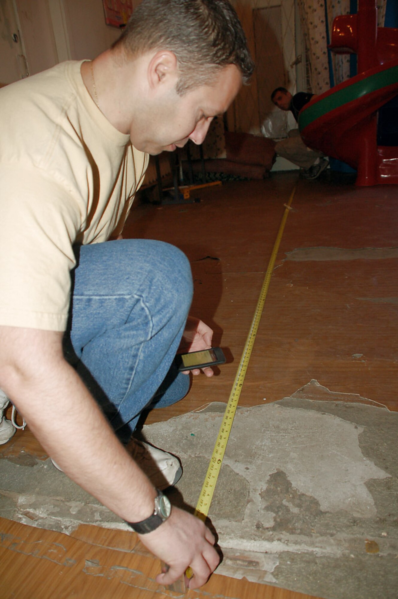 Tech. Sgt. Thomas Pettit takes floor measurements during a Feb. 25 visit to Kyrgyzstan's sole Children's Cancer Hospital in Bishkek. Sergeant Pettit is assigned to the 376th Expeditionary Medical Group and is deployed from Beale Air Force Base, Calif.  He is originally from Fort Wayne, Ind. (U.S. Air Force photo/Tech. Sgt. Phyllis Hanson)