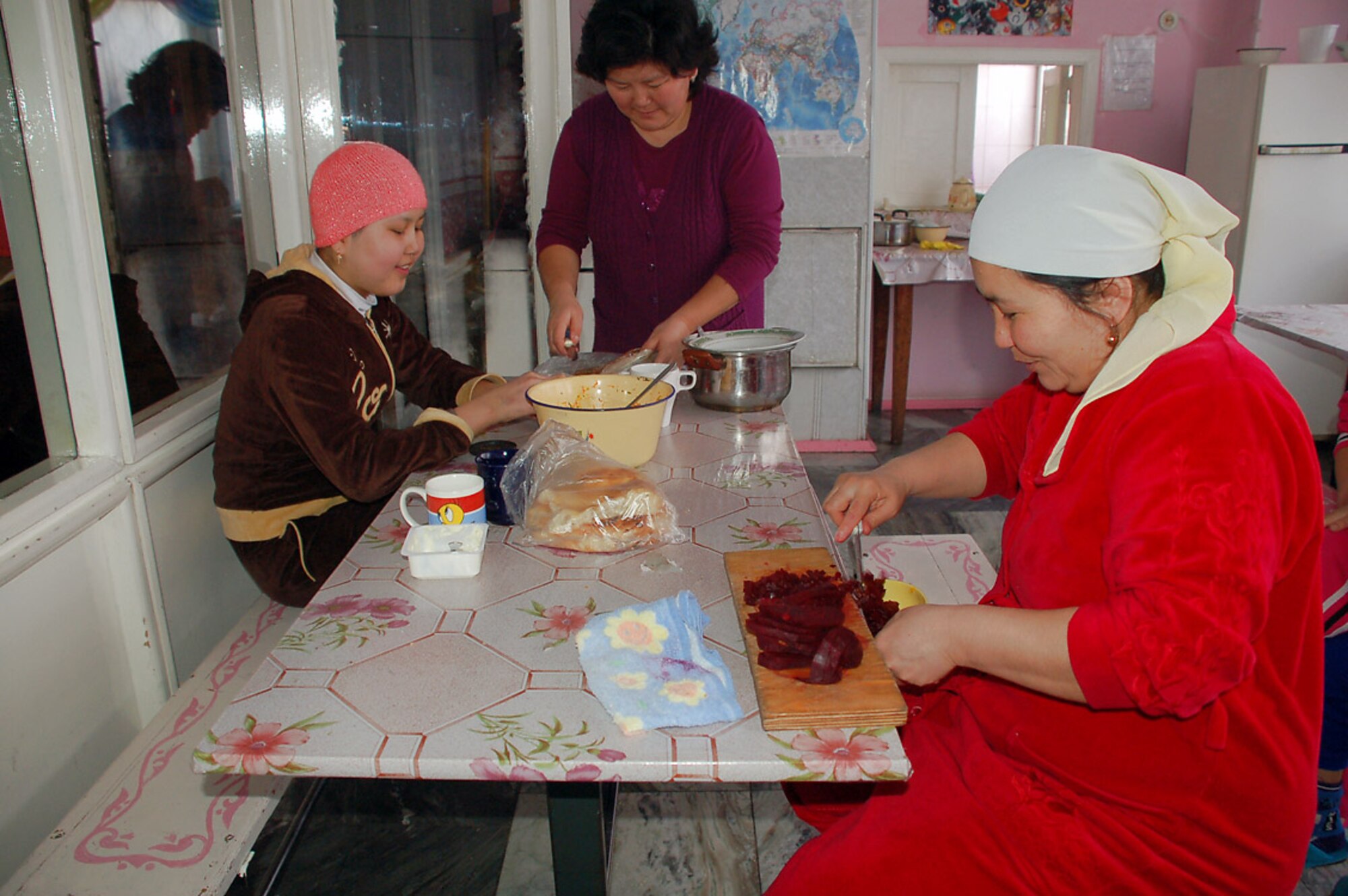 Kygyz mothers and a young girl with cancer prepare a lunch of beets, potatoes and raw herring for the children who are recovering cancer patients Feb. 25 at Kyrgyzstan's only Children's Cancer Hospital, located in Bishkek. To help the families get through the healing, Manas Air Base, Kyrgyzstan, volunteers visit with the children. (U.S. Air Force photo/Tech. Sgt. Phyllis Hanson)