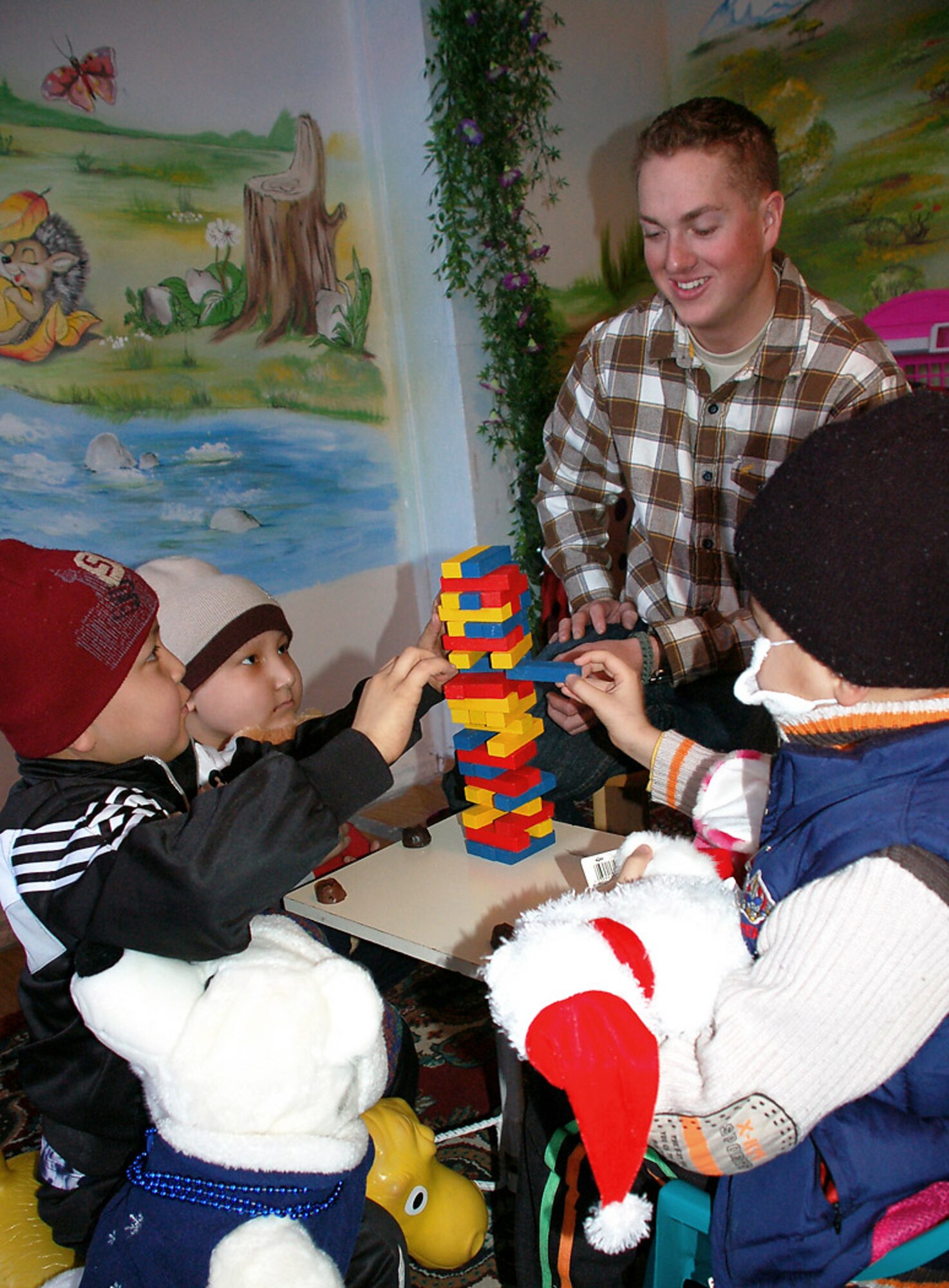 Airman 1st Class Adam McDonough plays a game of tumbling towers with Kyrgyz children who are recovering cancer patients Feb. 25 at Kygrystan's only Children's Cancer Hospital. Airman McDonough spent some of his off-duty time with others from Manas Air Base, Kyrgyzstan, who are members of the Manas Air Base Outreach Society, a private, nonprofit volunteer service organization that works to support a number of causes in the greater Bishkek area and communities near the base. Airman McDonough is assigned to the 376th Expeditionary Civil Engineer Squadron. He is deployed from Seymour Johnson Air Force Base, N.C., and is originally from Lake Elsinore, Calif. (U.S. Air Force photo/Tech. Sgt. Phyllis Hanson)