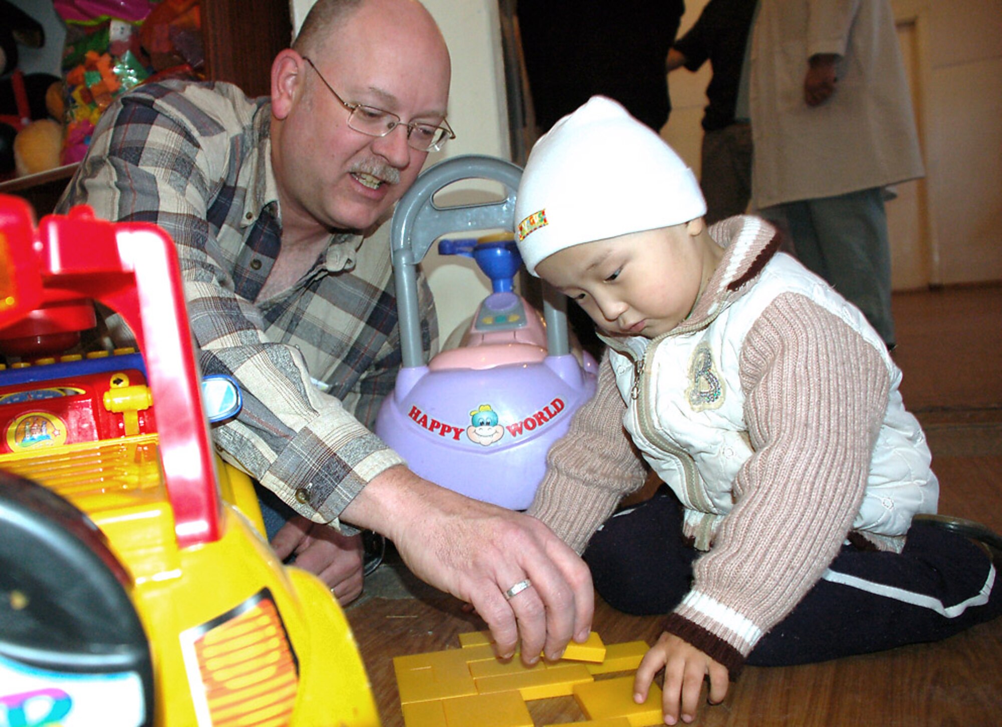 Master Sgt. Royd Chambers plays blocks with a child Feb. 25 at Kyrgyzstan's sole Children's Cancer Hospital. Sergeant Chambers spent some of his off-duty time with others from Manas Air Base, Kyrgyzstan, who are members of the Manas Air Base Outreach Society, a private, nonprofit volunteer service organization that supports a number of causes in the greater Bishkek area and communities near the base. Sergeant Chambers is an Iowa Air National Guardsman assigned to the 376th Expeditionary Airlift Wing Chaplain Office. He is deployed from the 185th Air Reserve Wing in Sioux City and is originally from Sheldon, Iowa. (U.S. Air Force photo/Tech. Sgt. Phyllis Hanson)