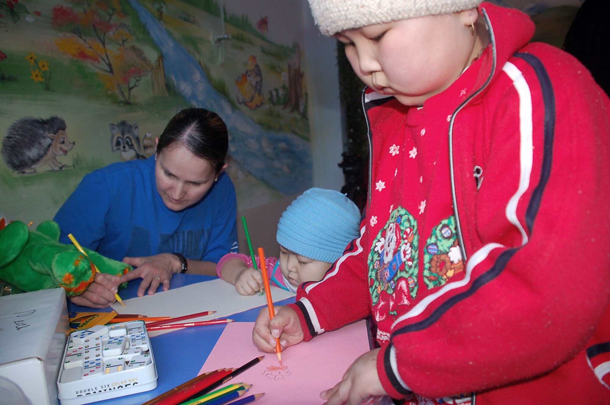 Tech. Sgt. Geraldine Clark draws pictures with children who are recovering cancer patients Feb. 25 at Kyrgyzstan's sole Children's Cancer Hospital. Sergeant Clark spent some of her off-duty time with others from Manas Air Base, Kyrgyzstan. Sergeant Clark is assigned to the 376th Expeditionary Medical Group and is deployed from Peterson Air Force Base. Colo. She is originally from Rosebud. S.C. (U.S. Air Force photo/Tech. Sgt. Phyllis Hanson)