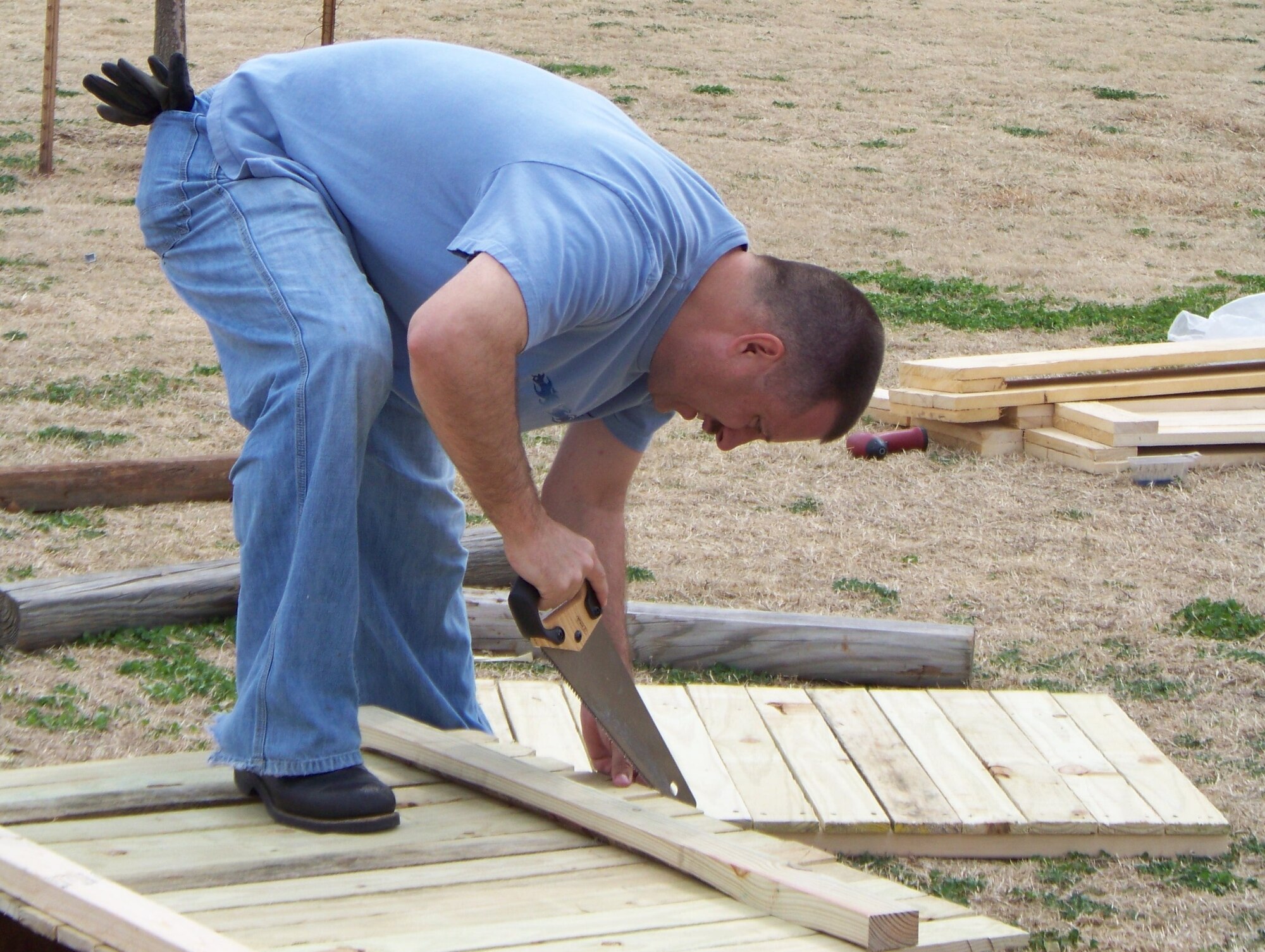 Master Sgt. Bruce Faris, 964th Airborne Air Control Squadron, works to construct a fence around the Moore Community Garden March 7. 