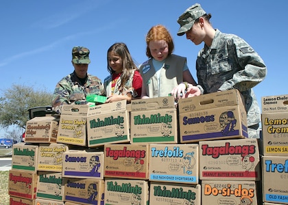 Tech. Sgt. Shauna Walker and Staff Sgt. Sunshine Scarbrough (far right), Air Force Personnel Center community outreach coordinators, receive 515 boxes of Girl Scout cookies from Samantha Frank and Madison Albrecht, Girl Scout Troop 2642 members, March 4 at Randolph Air Force Base, Texas. The 12-year-old girls raised the money to purchase the cookies from local businesses and community members. Each box includes an original poem written by Albrecht thanking the servicemembers for their service to the nation. The cookies will be shipped to deployed servicemembers in Iraq, Afghanistan and other locations in the Middle East. This is the second year Albrecht has raised money to purchase Girl Scout cookies for deployed servicemembers. (Air Force photo by Staff Sgt. Steve Grever)