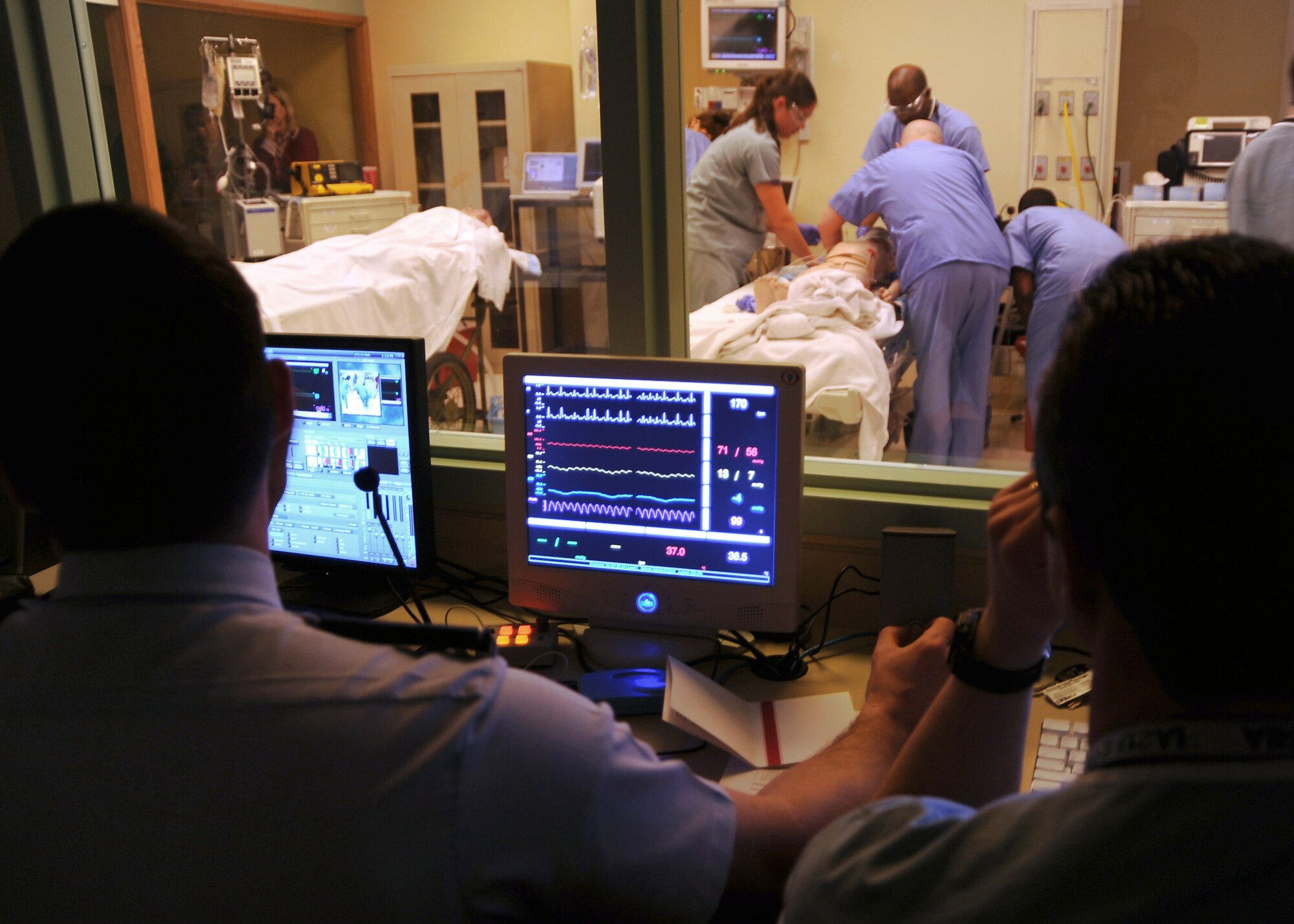 Instructors monitor patient blood pressure and vital signs during a simulation at the newly opened Emergency Trauma Simulation Lab Feb. 17 at the St. Louis University Hospital in Missouri. During varying scenarios, instructors can instantly change a patient's vital signs to see how the students react to a situation.(U.S. Air Force photo/Airman 1st Class Wesley Farnsworth) 
