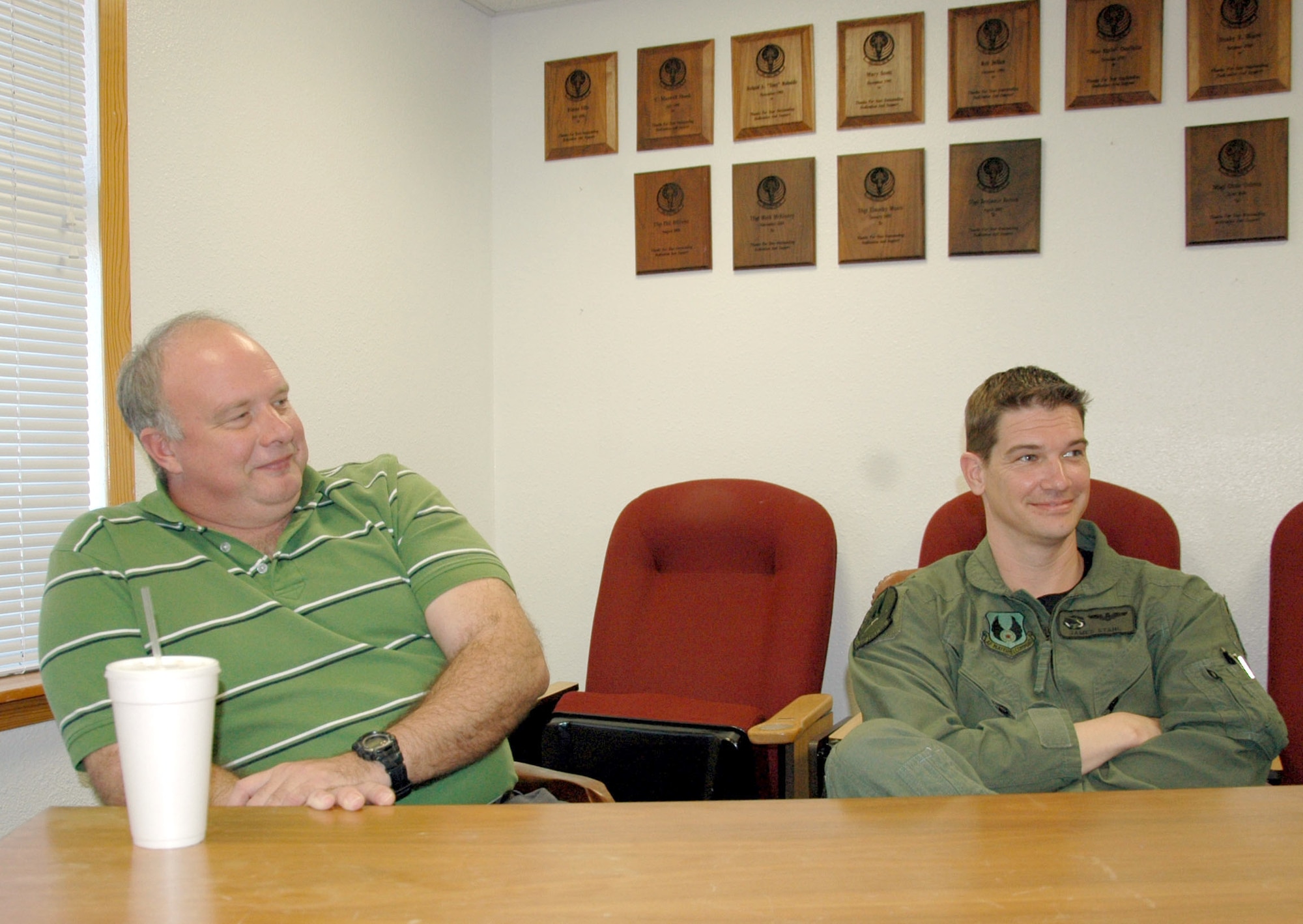 HURLBURT FIELD, Fla. - Andy White and Maj. James Stahl, test pilots with the 413th Flight Test Squadron, listen to other squadron members recently at their conference room at Hurlburt Field. The 413th FLTS fly test missions for special operations airframes. (U.S. Air Force photo/Noel Getlin)
