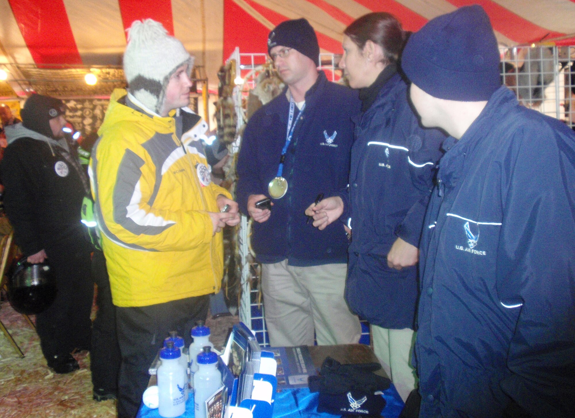 Master Sgt. Rob Veuleman, Senior Master Sgt. Jackie Foster and Staff Sgt. Jacob Watson talk to a snowmobile fan inside a tent at the International 500 Snowmobile Race in Sault. St. Marie, Mich. The three are assigned to the 339th Recruiting Squadron. (Courtesy photo) 