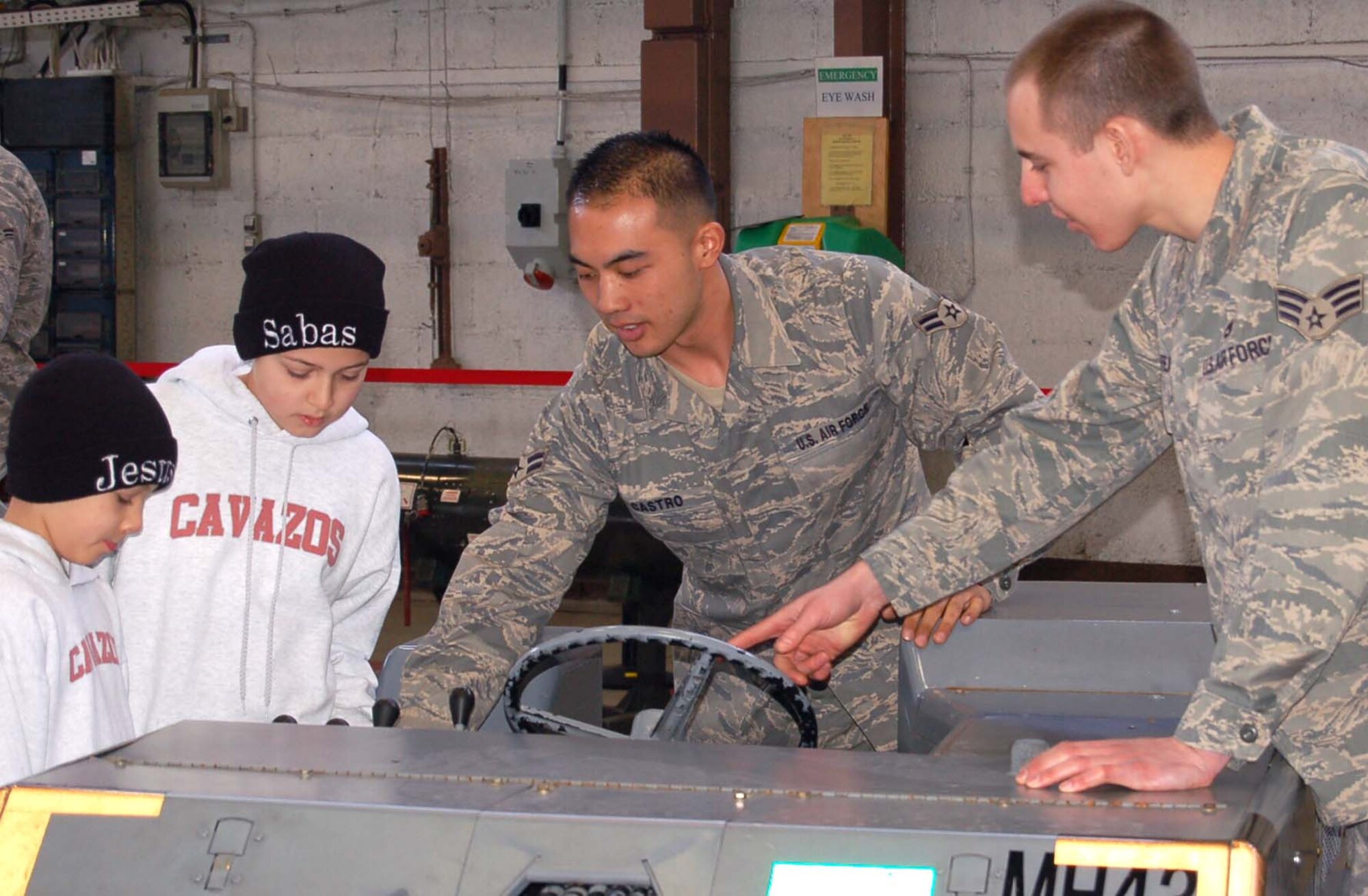SPANGDAHLEM AIR BASE, Germany – Airman 1st Class Thomas Castro and Senior Airman Michael Feauto show Bitburg Middle School students how to work a MHU-83 Bomb Lift Truck during Job Shadow Day March 2, 2009. Both Airmen are assigned to the 52nd Equipment Maintenance Squadron. (Courtesy photo)