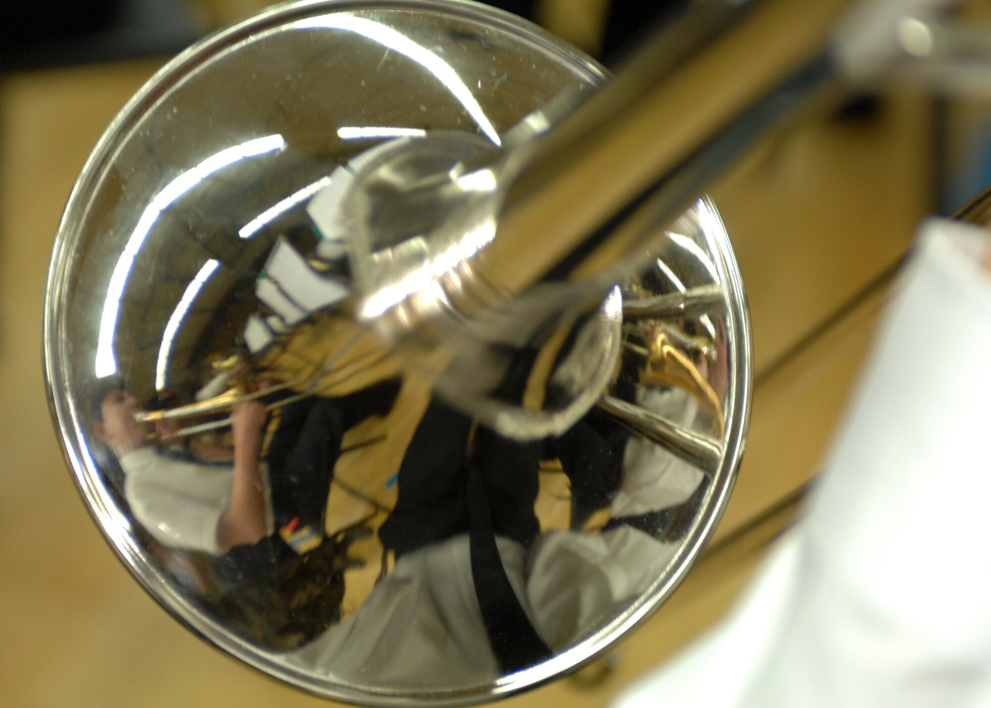 SPANGDAHLEM AIR BASE, Germany -- Musicians from the trombone section are reflected on the bell of a trombone March 4, 2009 at the Skelton Memorial Fitness Center. Advanced middle school and high school band students from Department of Defense schools performed for the Spangdahlem community as members of the Kaiserslautern School District Honor Band. (U.S. Air Force photo Senior Airman Jenifer H. Calhoun)