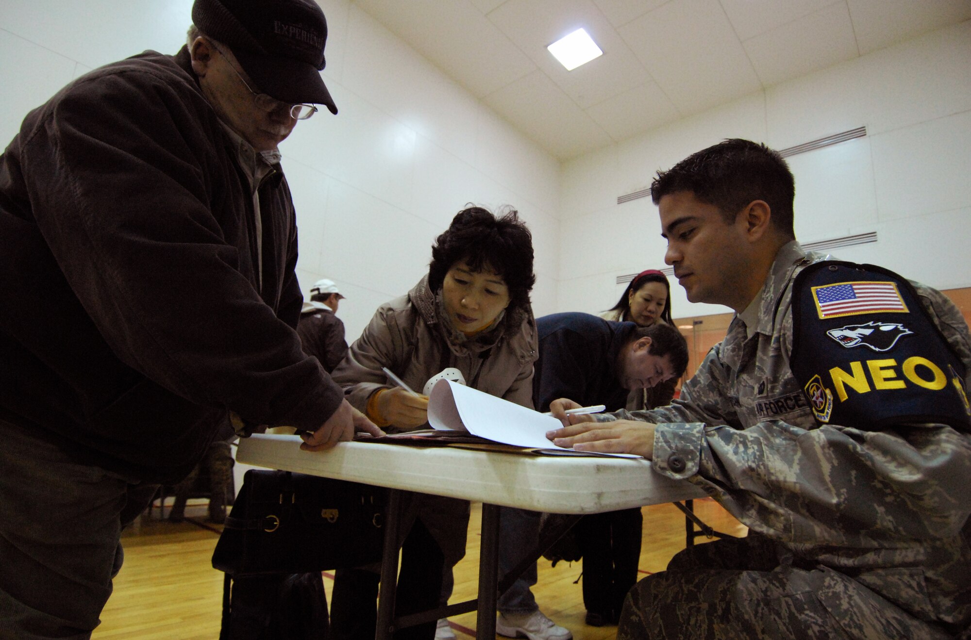 Senior Airman Thomas Hutchins, 8th Comptroller Squadron, reviews a non-combatant's paperwork during the Non-combatant Evacuation Operation inspection at Kunsan Air Base, Republic of Korea, March 7, 2009. The NEO inspection tests the 8th Fighter Wing's capabilities to evacuate non-combatants from the country. (U.S. Air Force Photo/Senior Airman Gustavo Gonzalez)