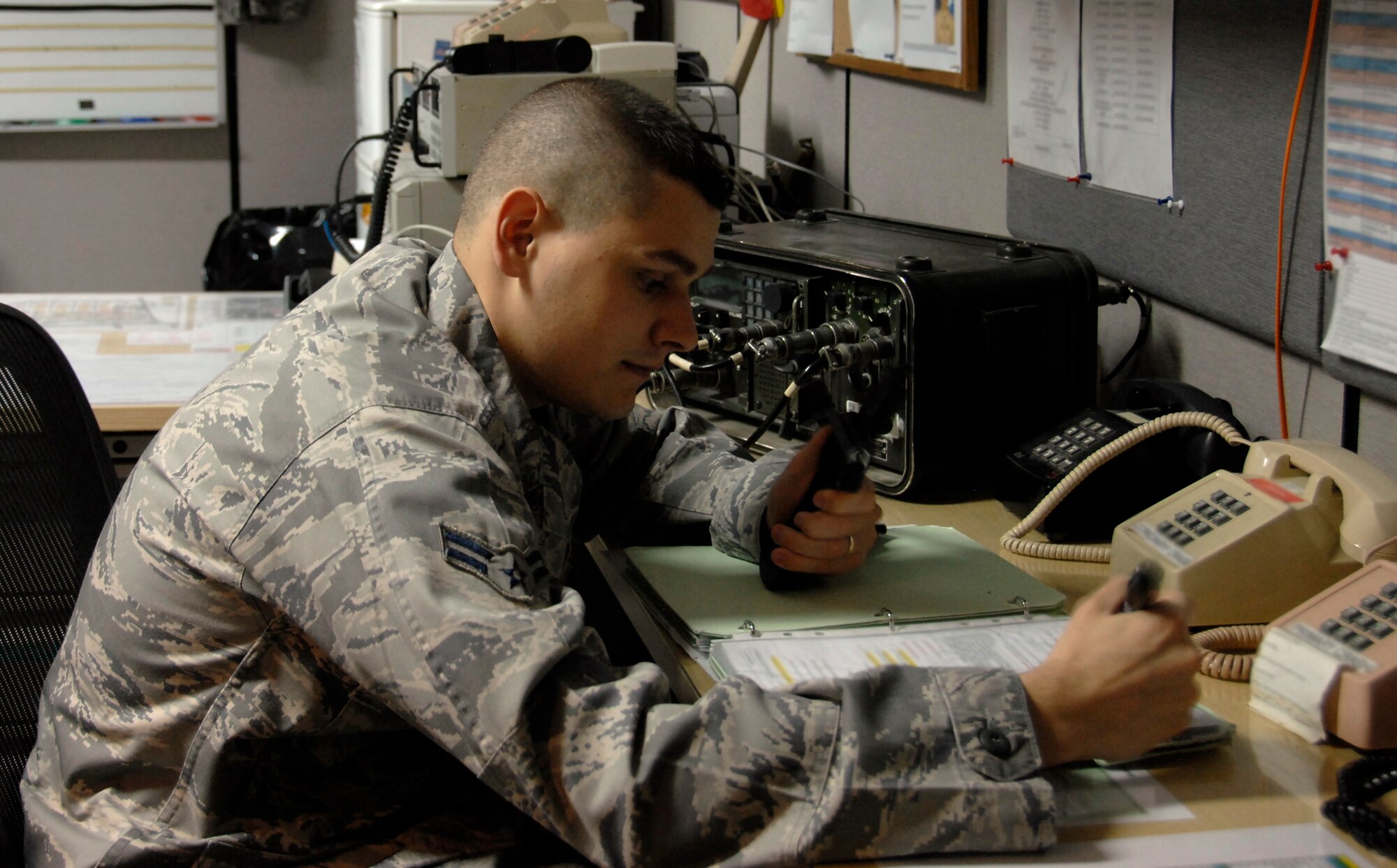 SOUTHWEST ASIA -- Airman 1st Class Todd Wireman, 380th Air Expeditionary Wing Command Post, reviews the in-flight emergency procedures checklist. Airman Wireman ensures proper agency and commander notification of any emergency related to the 380th AEW operations. (U.S. Air Force photo by Staff Sgt. Mike Andriacco) (Released)