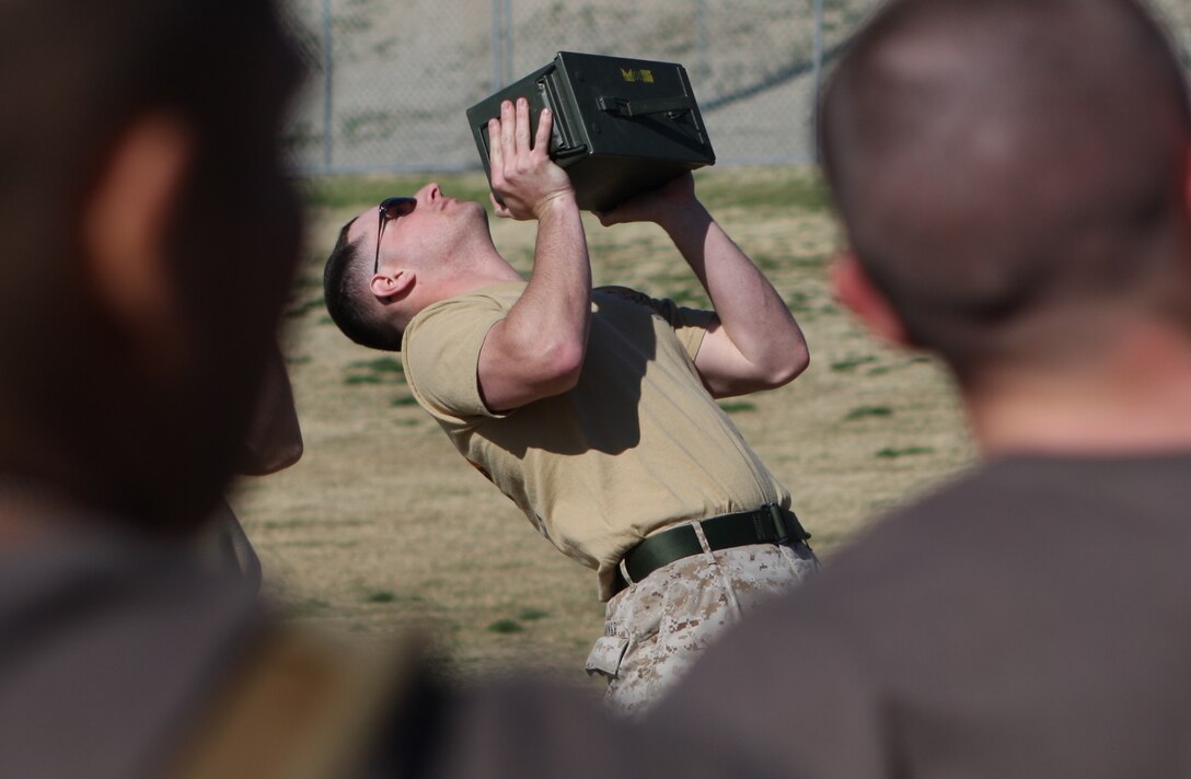 Sgt. Parker, a Corporals Course instructor, demonstrates the proper way to do an ‘ammo-can lift,’ one of the exercises in the Combat Fitness Test that the Marines in the course participated in March 10.