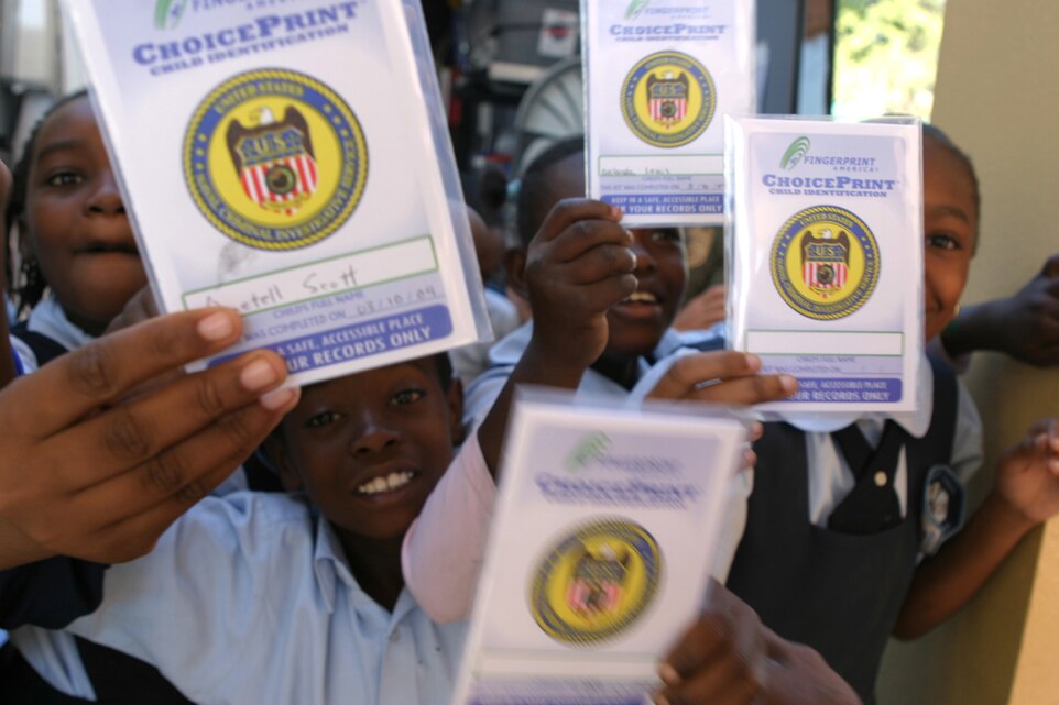 NASSAU, Bahamas (March 10, 2009) - Woodcock Primary School students show off their new child identification kits. NCIS, in cooperation with the U.S. Embassy, Nassau, took fingerprints for and provided the identification kits to more than 200 students at the primary school. The agents, out of the NCIS South East Field Office, Jacksonville, Fla., are on the island with Exercise Tradewinds 2009, providing training to law enforcement which will support maritime security in the Caribbean Basin. Tradewinds 09 is a Chairman of the Joint Chiefs of Staff directed, U.S. Southern Command-sponsored exercise that is conducted in cooperation with Caribbean Basin partner nations. (Photo by Staff Sgt. A.C. Mink)
