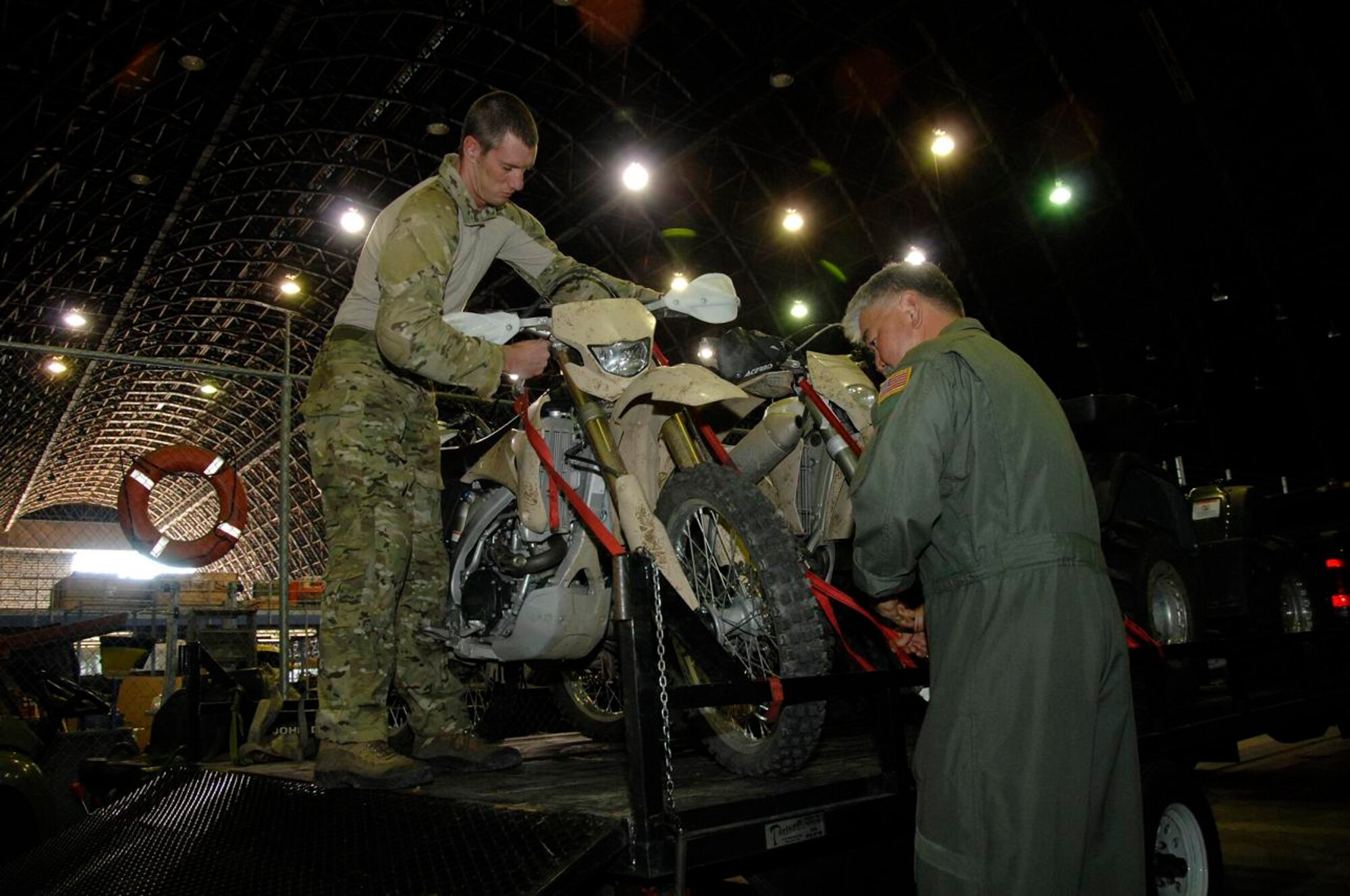 Tech. Sgt. Sean Kirsch and Senior Master Sgt. Larry Hiyakumoto, pararescuemen from the 131st Rescue Squadron, Moffett Federal Airfield, California Air National Guard, prepare a set of all terrain motorcycles for routine inspection March 10.  Sergeants Kirsch and Hiyakumoto used their specialized life saving skills to assist an accident victim near Suisun, Calif., March 9. (U.S. Air Force photo by Tech. Sgt. Ray Aquino)
