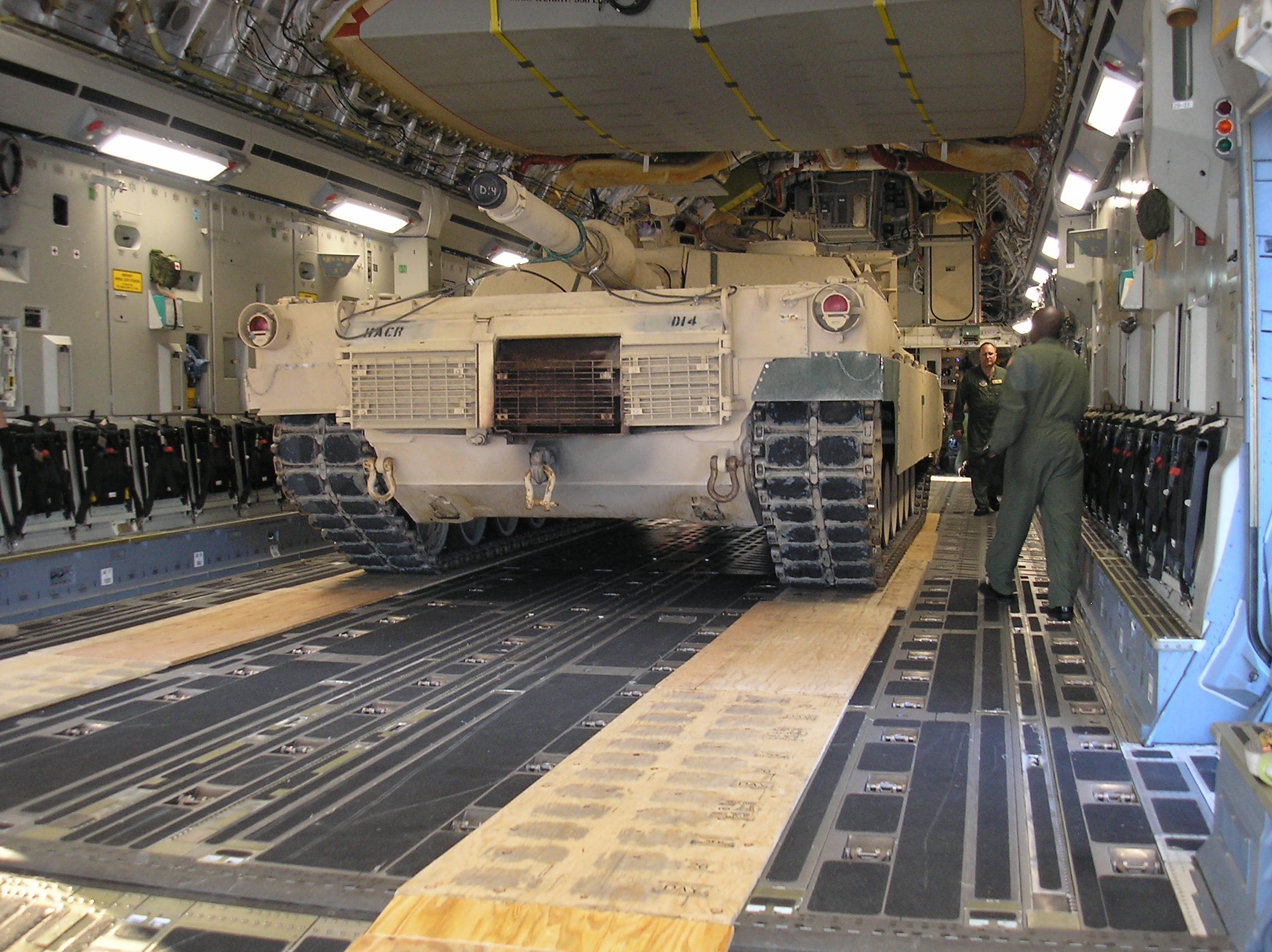 Members of the 452d TALCE, 50th and 56th Aerial Port Squadrons, and 729th Airlift Squadron remove boards used for traction in loading the M1 Abrams tank into a C-17. The tank was transported to March to train ground crews and aircrews to upload, off-load and fly the tank in preparation for upcoming deployments. (U.S. Air Force photos courtesy Tech. Sgt. Julie Stanyer)