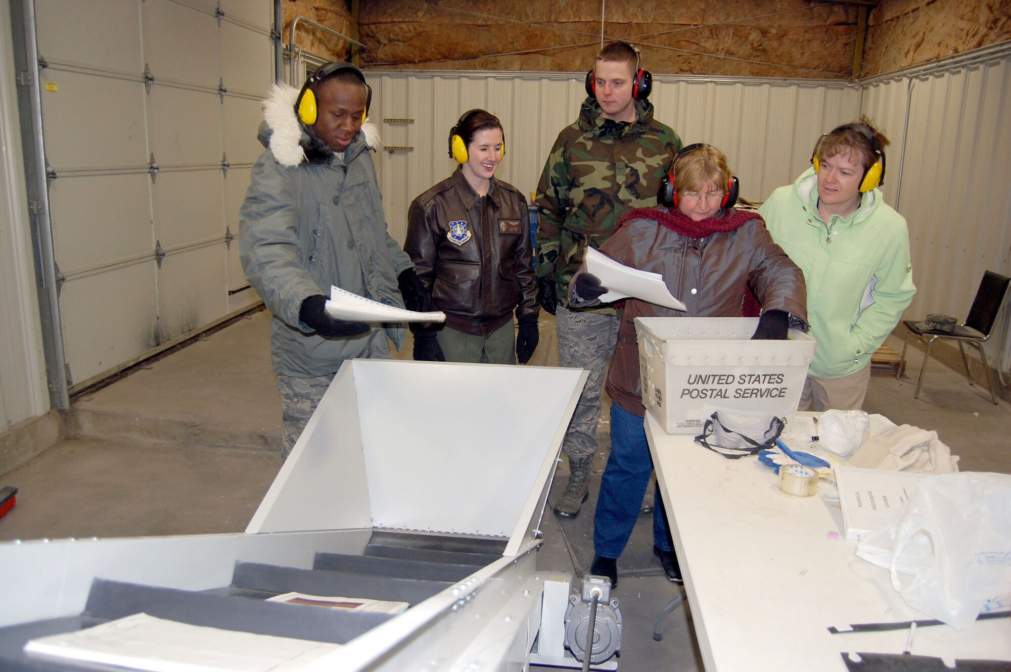 (Left to right) Airman 1st Class Quintin Gilmore, Capt. Liz Buss, Airman 1st Class Alan Steele and Brook Gerard, get hands-on training from Eileen Gallagher (second from right) at the base's central destruction facility March 10. Beginning March 17, the wing implements the 100 percent shred policy for all paperwork and materials generated on base. Before being able to use the base's central destruction equipment, all personnel must receive training first. For more information on the central destruction facility, call Ms. Gallagher at 731-2266. (U.S. Air Force photo/Staff Sgt. Eydie Sakura)
