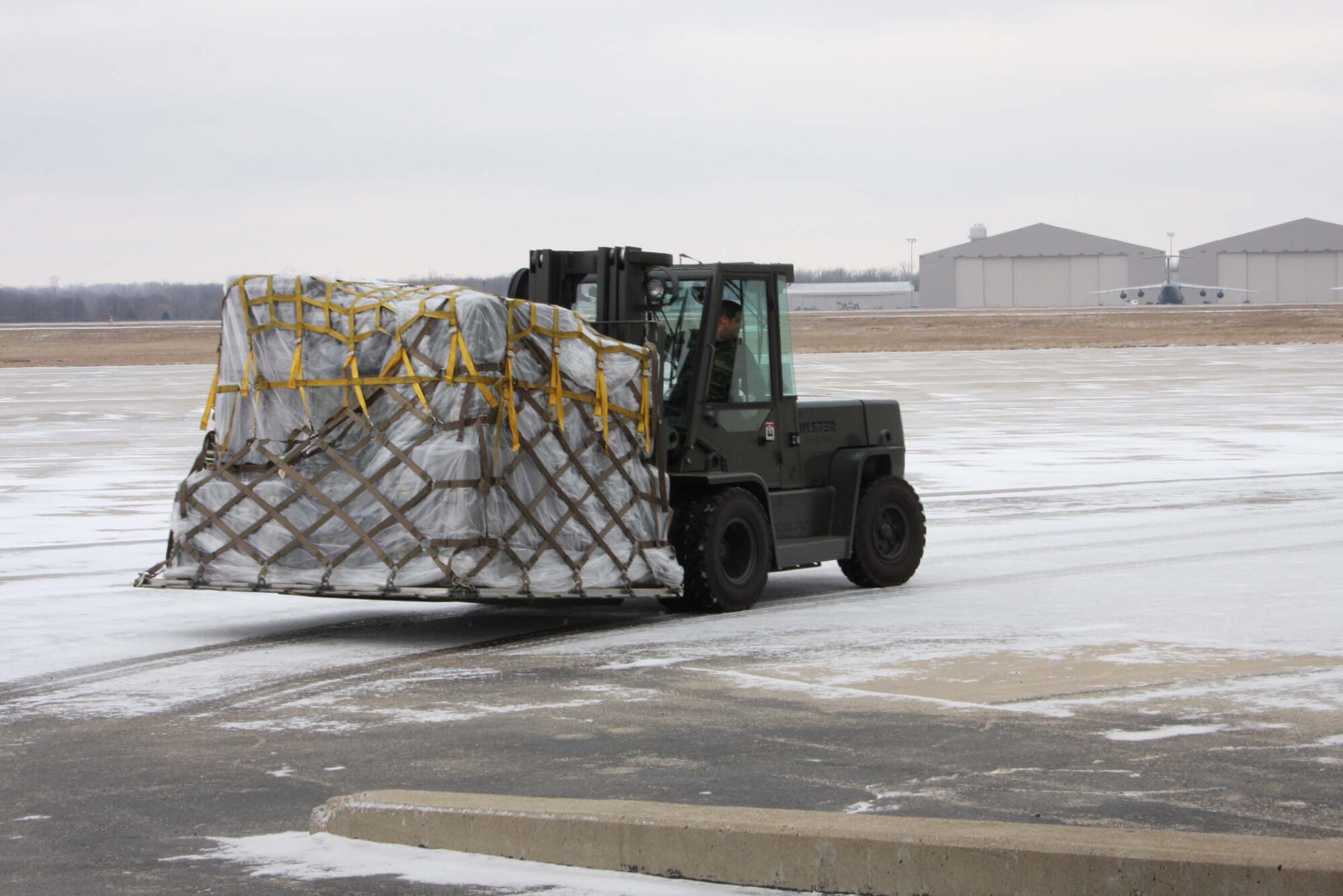 WRIGHT-PATTERSON AFB, Ohio – Senior Airman Russ Hernandez, 87th Aerial Port Squadron, maneuvers a fork lift to move a pallet across the flight line as part of a pallet building training scenario. The squadron spent the weekend building and moving pallets to prepare for future deployments. (Air Force photo/Senior Airman Ken LaRock) 