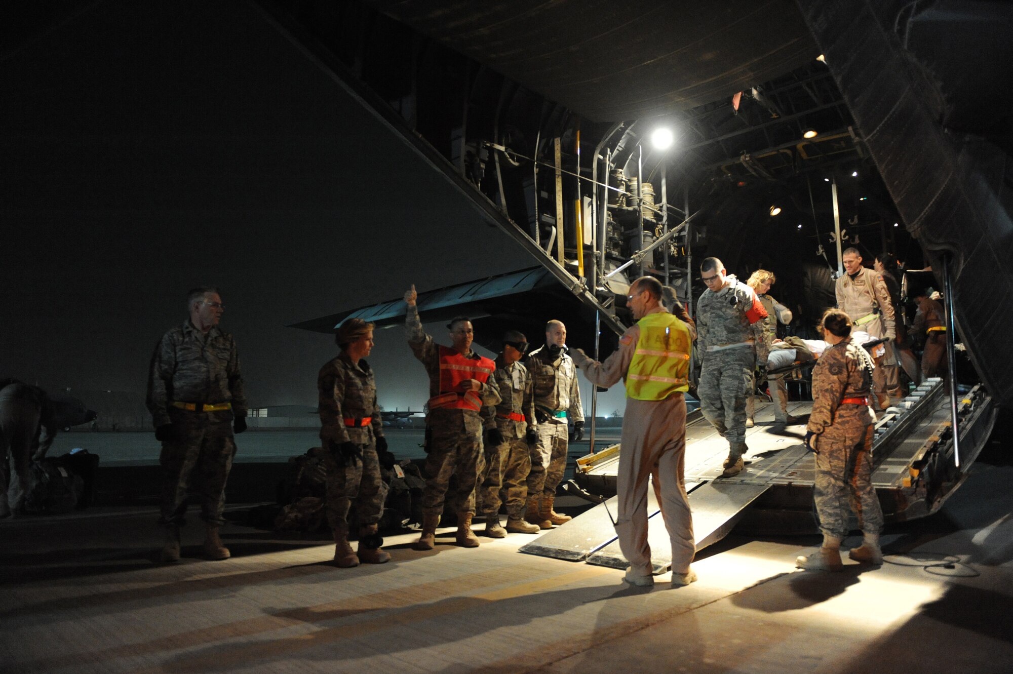 JOINT BASE BALAD, Iraq ? Members of the 332nd Expeditionary Operations Support Squadron?s Expeditionary Aeromedical Evacuation Flight; Airmen from the 332nd Expeditionary Medical Group Contingency Aeromedical Staging Facility; and volunteers wait with stretchers and buses to off-load patients here after an aeromedical evacuation mission Feb. 27. The 332nd EAEF transports servicemembers wounded, injured or sick from remote locations to a higher level of medical care. (U.S. Air Force photo/Senior Airman Elizabeth Rissmiller)