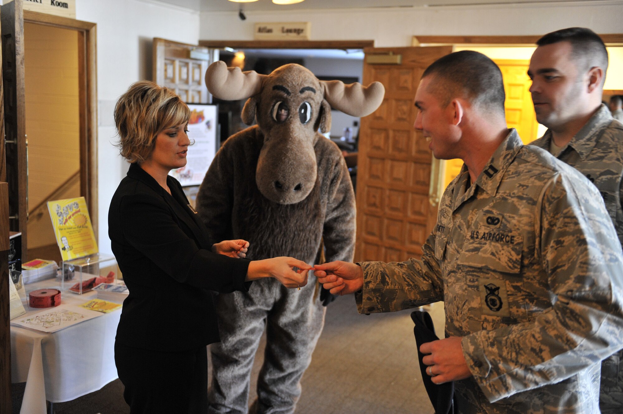 Staci Corder, 341st Force Support Squadron marketing director, hands out raffle tickets to Team Malmstrom members prior to the start of the promotion ceremony Feb. 27. Prizes were given away to lucky winners in a random drawing following the ceremony to officially kick-off the "Saving with our Services" club membership drive that runs through the month of March. (U.S. Air Force photo/John Turner)