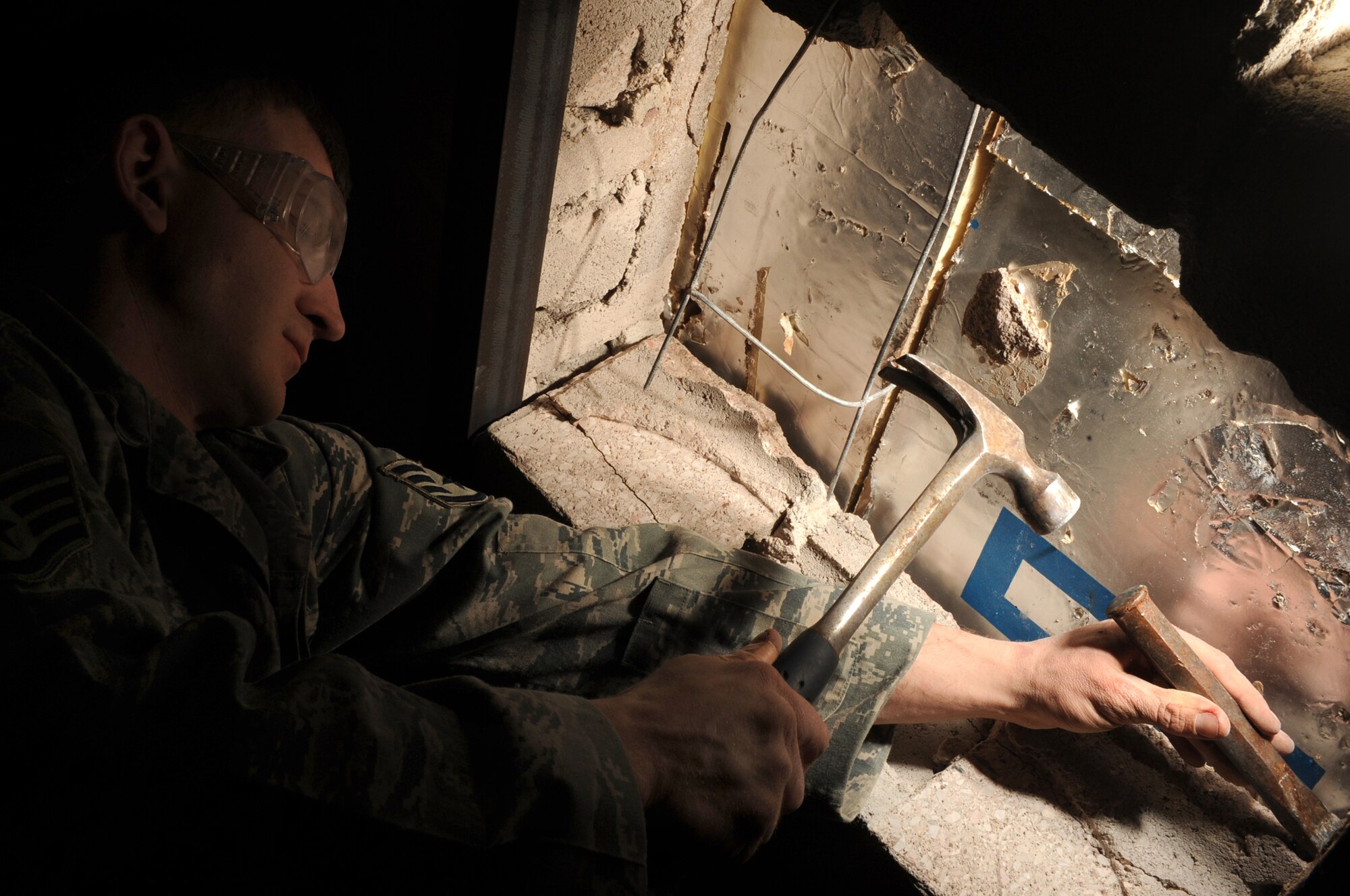Staff Sgt. Timothy Wilson, 28th Civil Engineer Squadron structural craftsman, uses a hammer and chisel to break up metal block ties from a wall for a ventilation system at the future Airmen Ministry Center here, March 5. The center will be a place where Airmen can interact while enjoying entertainment and snacks. (U.S. Air Force photo/Airman 1st Class Joshua J. Seybert) 