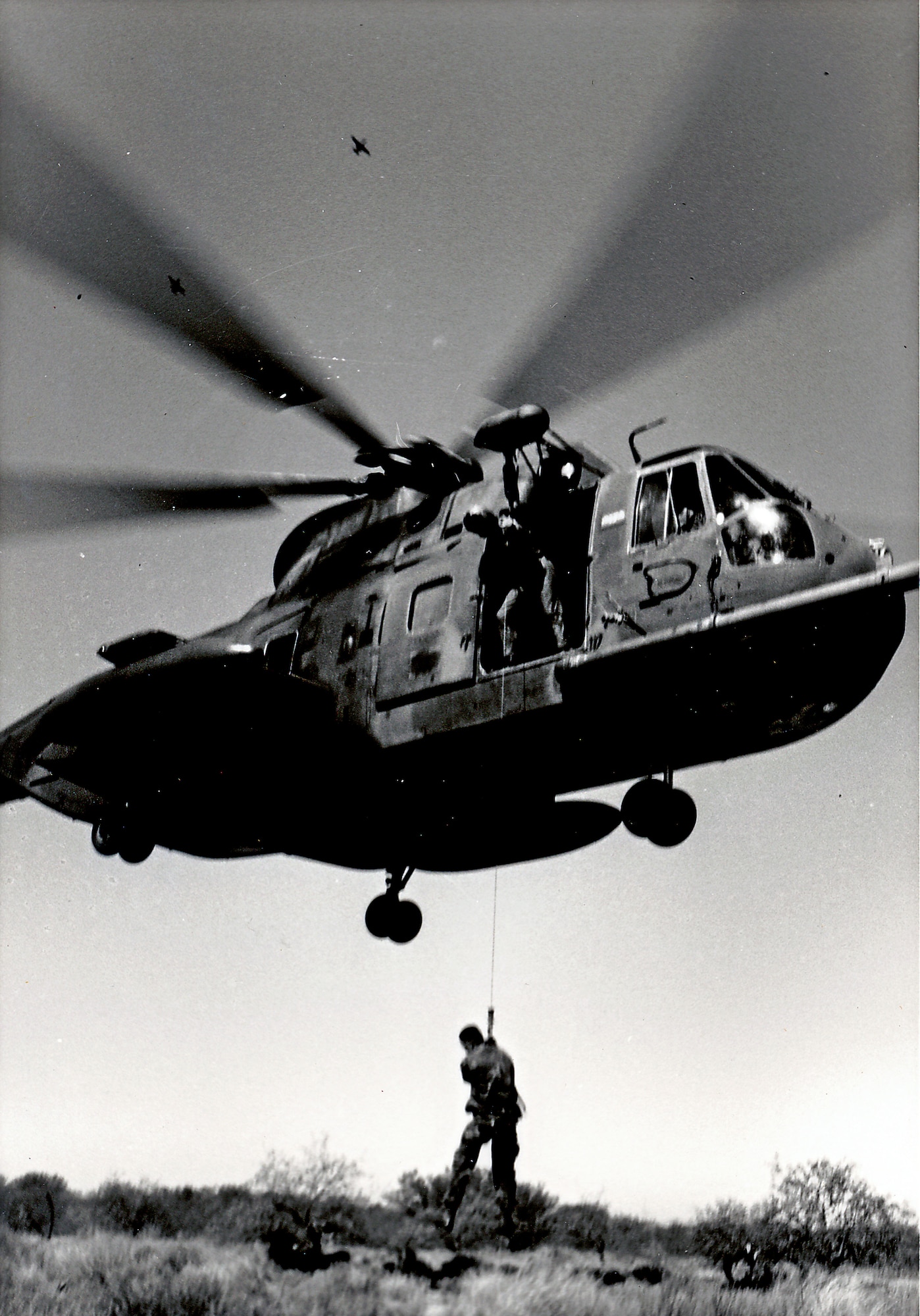 A 71st SOS HH-3E Jolly Green Giant helicopter hoists a reservist during a training mission in the Southern Arizona desert in the late 1980s. (Courtesy photo)
