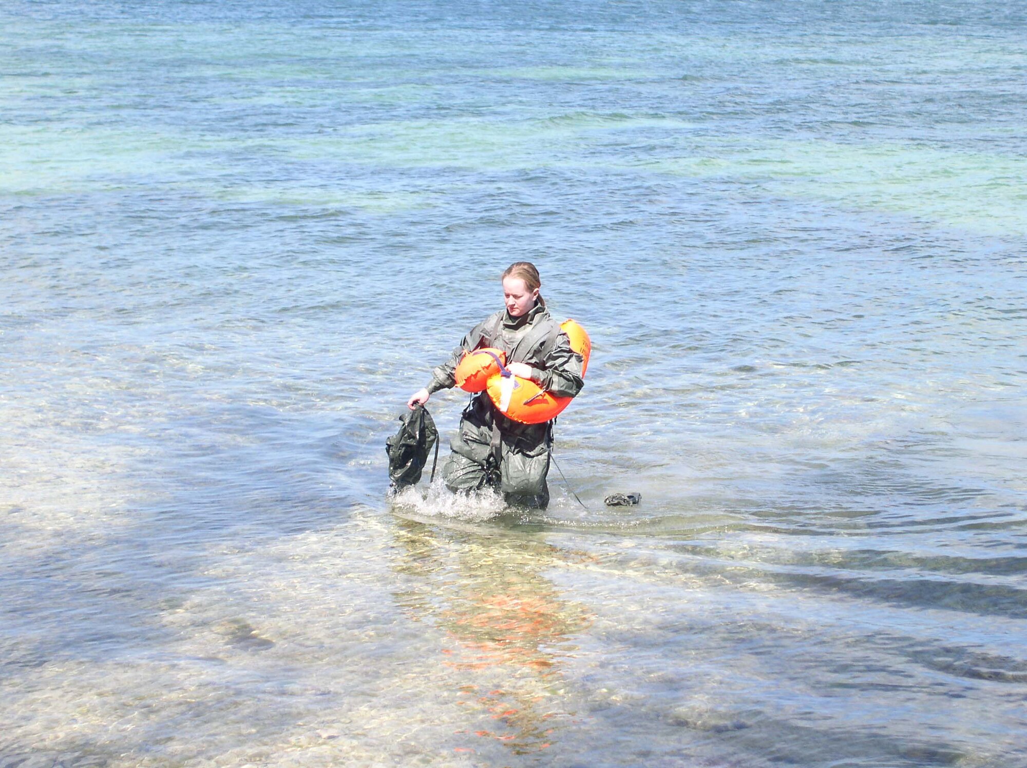 WRIGHT-PATTERSON AFB, Ohio – Senior Airman Kortnee Widup, 445th Operational Support Squadron, gathers up her gear as she walks out of the marina during water survival training wearing a CWU16 anti-exposure suit.  The water-tight suit is worn by aircrews when they are flying over cold water areas. It covers the entire body and adds an hour to surviving in frigid water. (Air Force photo/Lt. Col. Jim Couzins) 