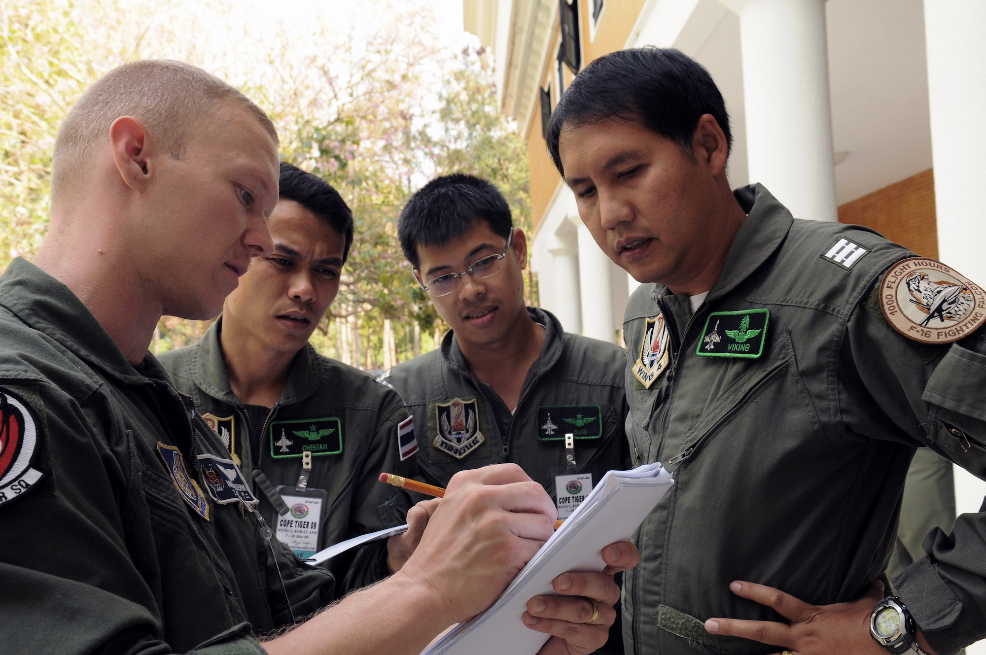 Capt. Mike Kuehni discusses flight operations with Royal Thai Air Force Squadron Leader S. Sak, Wing Commander N.Don, and Wing Commander Nm. Rat at Korat Royal Thai Air Force Base, Thailand, March 9. Cope Tiger is an annual, multilateral large force aerial exercise conducted in Thailand including U.S., Thai and Singaporean military forces. The two-week exercise includes both flying and humanitarian missions conducted in Korat and Udon Thani, Thailand. Cope Tiger 2009 kicked off March 9 and will conclude March 20. Captain Kuehni is deployed to Cope Tiger 2009 from the 44th Fighter Squadron at Kadena Air Base, Japan. (U.S. Air Force photo/Staff Sgt. Angelique Perez)