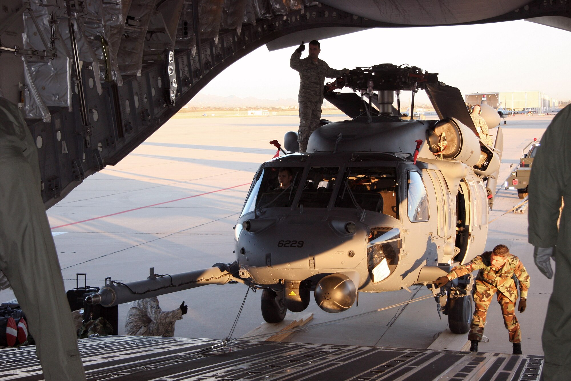 Aircraft maintainters from the 943rd Maintenance Squadron prepare to load a HH-60G Pave Hawk helicopter onto a C-17 Globemaster III March 7 at Davis-Monthan Air Force Base, Ariz. Two helicopters were loaded onto the C-17 from McChord Air Force Base, Wash, and deployed to Patrick AFB, Fla., to augment the launch of the Space Shuttle Discovery. Twenty reservists from the 943rd Rescue Group are supporting this mission. (U.S. Air Force photo/Master Sgt. Ruby Zarzyczny) 
