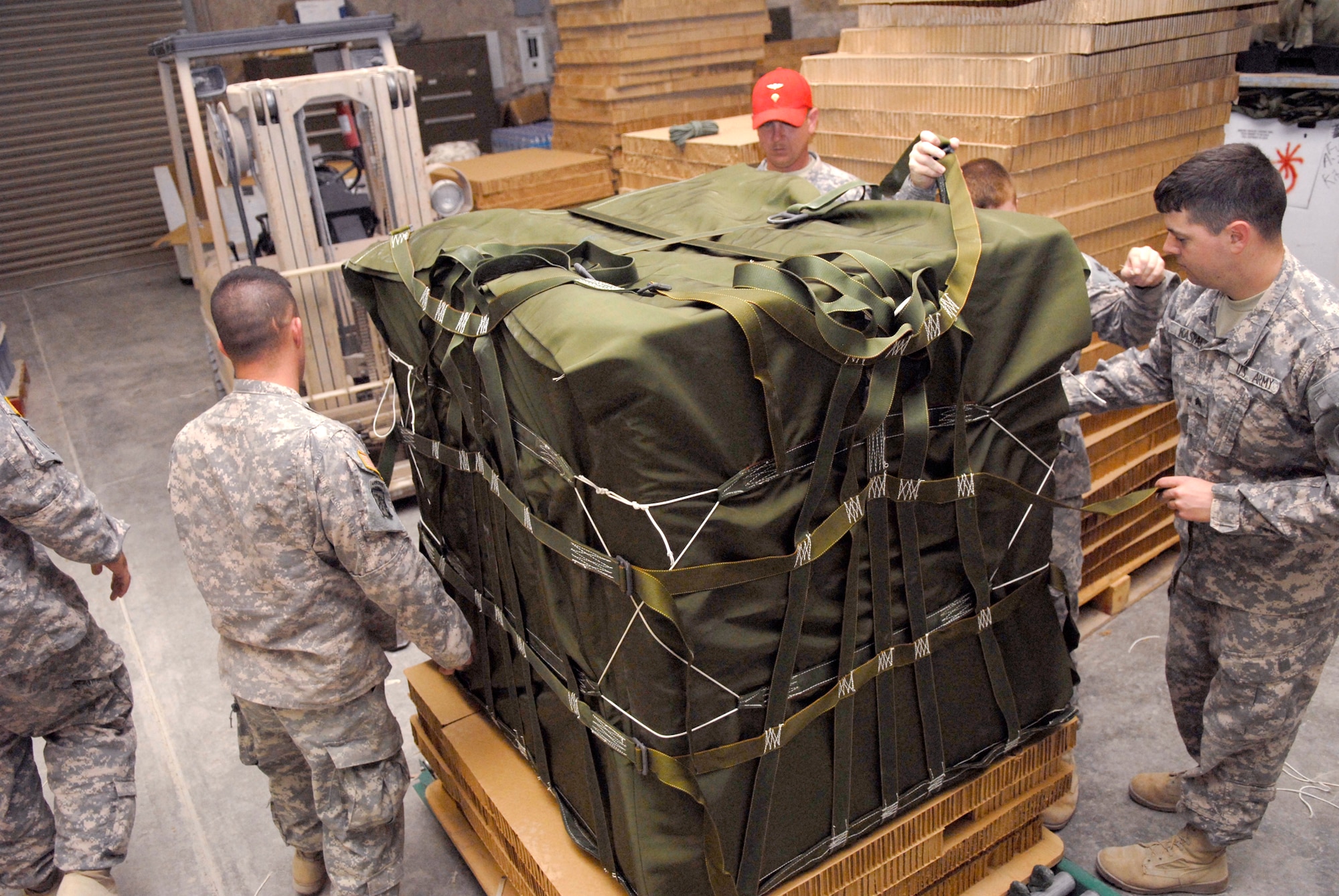 The 824th Quartermaster Company Detachment 7 Riggers prepare a commodity package containing 32 cases of 1.5 liter bottles of water to be air dropped in the U.S. Central Command's area of responsibility (AOR), Mar. 9, 2009, at an undisclosed location in Southwest Asia.  Shipments of food, ammunition, and fuel prepared by the riggers can be destined for any coalition forces on the ground across the AOR, in support of Operations Iraqi and Enduring Freedom and Combined Joint Task Force - Horn of Africa.  (U.S. Air Force Photo by Senior Airman Andrew Satran/Released)