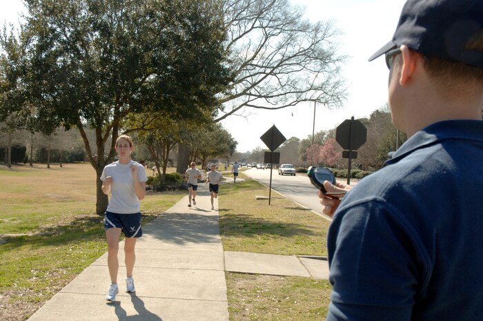 Shawn McKeen records time as Suzanne Jumper crosses the finish line during the Commander's Fitness Challenge 5,000-meter run here March 6. More than 350 Airmen from various squadrons participated in the run. Jumper was the first female to cross the finish line at 23:40 and is assigned to the 437th Civil Engineer Squadron. McKeen is assigned to the 437th Force Support Squadron. (U.S. Air Force photo/Staff Sgt. Marie Cassetty)
