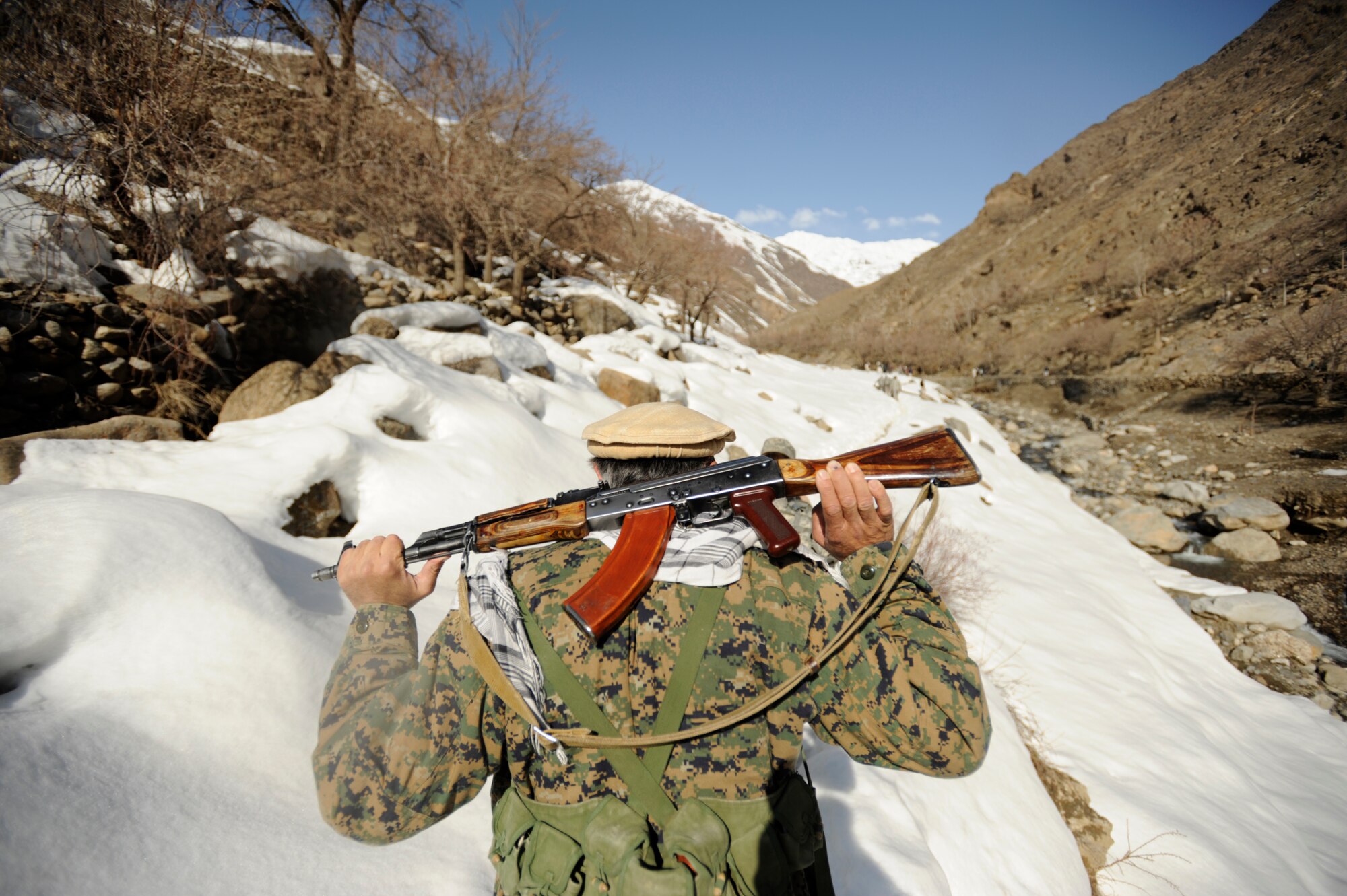 A Mujahadeen Guard walks with U.S. Military members of the Afghanistan Panjshir Provincial Reconstruction Team  during a site visit Mar. 5, 2009, in support of Operation Enduring Freedom. (U.S. Air Force photo by Staff Sgt. James L. Harper Jr.)
