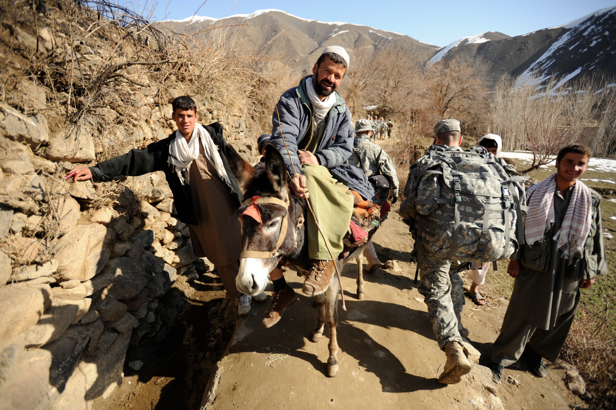 U.S. Army Sgt. Ramon Guzman, Panjshir Provincial Reconstruction Team (PRT) Civil Affairs, walks past villagers during a site visit in Afghanistan's Panjshir Valley Mar. 5, 2009, in support of Operation Enduring Freedom. (U.S. Air Force photo by Staff Sgt. James L. Harper Jr.)