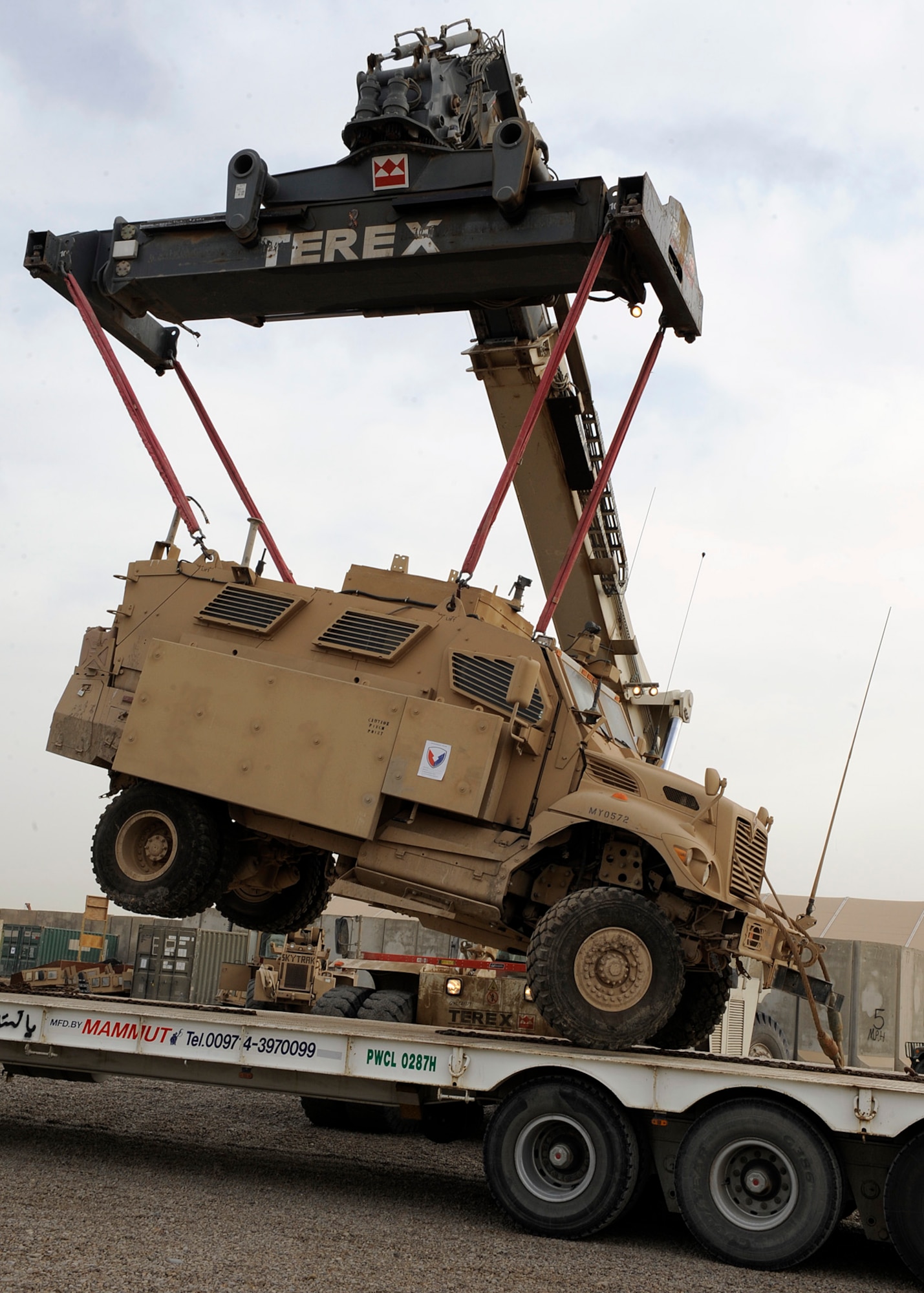 A crane lowers a mine resistant ambush protected vehicle onto the bed of a semi truck at Camp Liberty, Iraq on Feb. 27, 2009. The MRAP will be prepared for a tractor-trailer convoy transport. One of the things the redistribution property assistant team does is being able to issue military vehicles out to the Army for either combat or support operations. The personnel at the yard have been able to process more than $1 billion worth of equipment during their six month deployment.  (U.S. Air Force Photo by Senior Airman Jacqueline Romero)