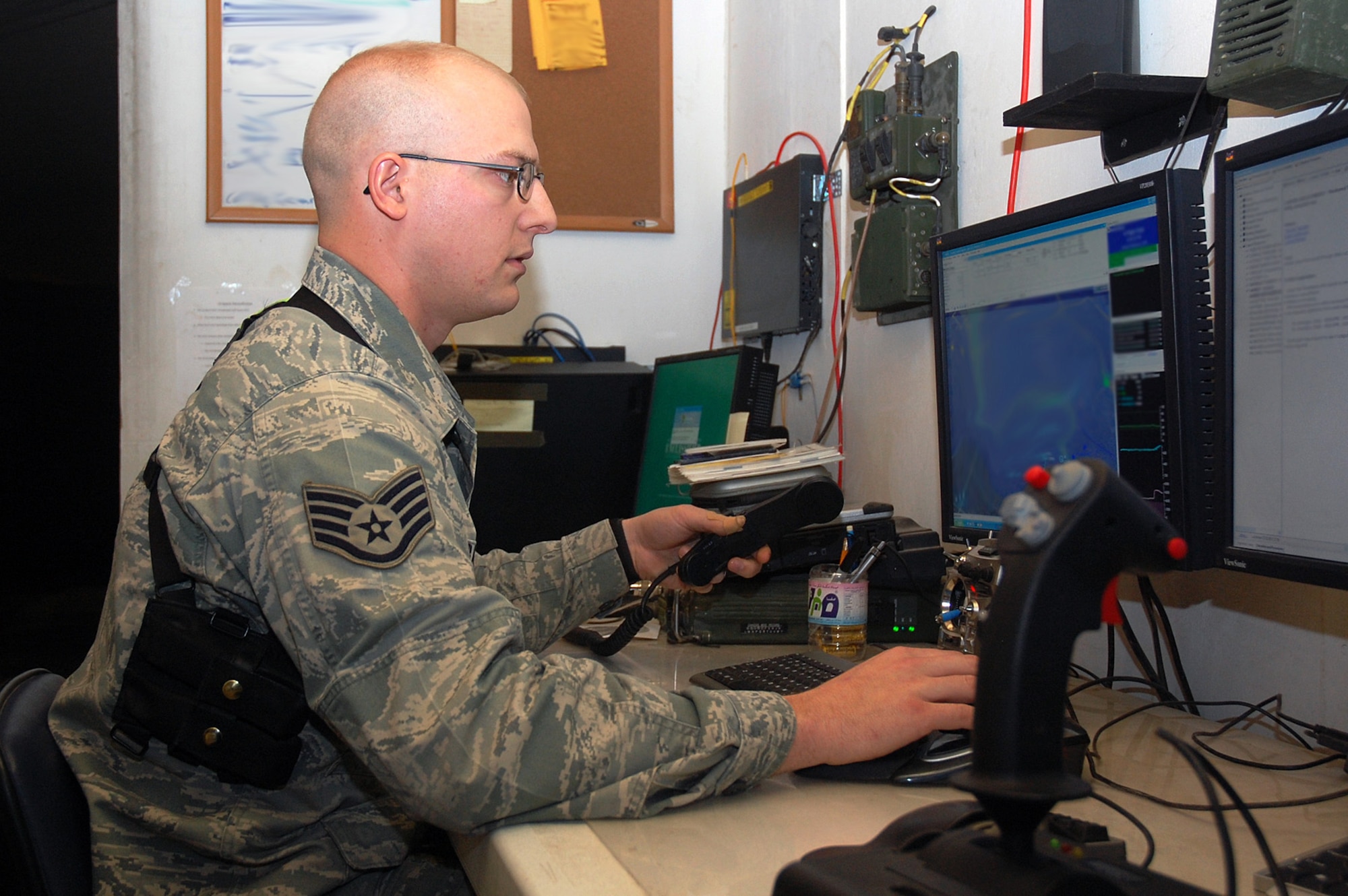 CAMP BUCCA, Iraq -- Staff Sgt. Christopher Banks, 887th Expeditionary Security Forces Squadron Scan Eagle operator, pilots a Scan Eagle unmanned aerial system from a trailer at Burge Field. The Scan Eagle is operated by a pilot and a sensor operator and can be used to detect IEDs and provide overwatch for patrols and convoys. Sergeant Banks is from Gilford, N.H. (U.S. Air Force photo illustration by Staff Sgt. Thomas J. Doscher)