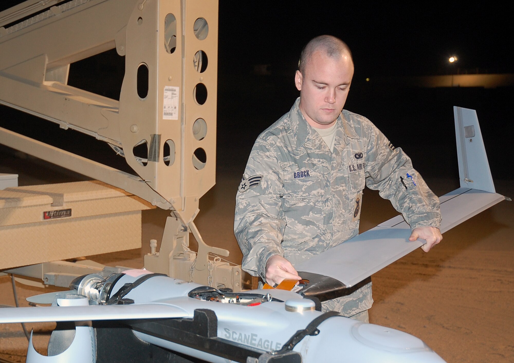 CAMP BUCCA, Iraq -- Senior Airman David Brock, 887th Expeditionary Security Forces Squadron Scan Eagle maintainer, attaches a wing to a Scan Eagle unmanned aerial system before flight Feb. 25. Scan Eagle operators and maintainers are drawn from regular 887th ESFS units and had to apply, interview and be accepted into the program. Airman Brock is originally from Daytona Beach, Fla.  (U.S. Air Force photo by Staff Sgt. Thomas J. Doscher)