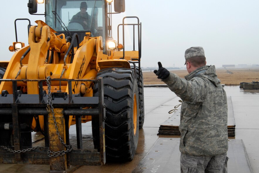Staff Sgt. Christopher Roberts, 8th Civil Engineer Squadron, directs a forklift into place during an Airfield Damage Repair exercise at Kunsan Air Base, Republic of Korea, March 5, 2009. ADR is a temporary fix on damage caused to the airfield by enemy fire to allow aircraft to quickly get back in th air. (U.S. Air Force Photo by SSgt Jason Colbert)