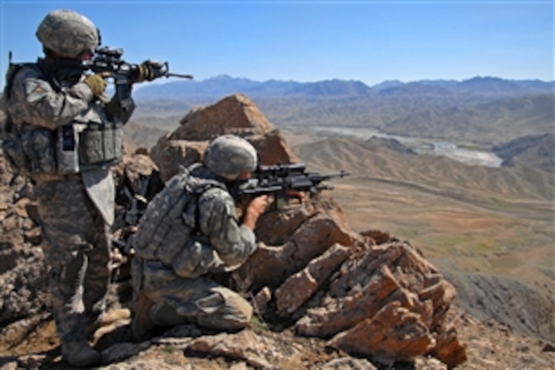 U.S. Army Staff Sgt. Salvador Lopez, left, and Spc. Jeffery Lewis, use the scopes on their weapons to scan for the enemy from a mountain ridge near Forward Operation Base Lane in Zabul province, Afghanistan, March 8, 2009. Lopez and Lewis are assigned to Company B, 1st Battalion, 4th Infantry Regiment.