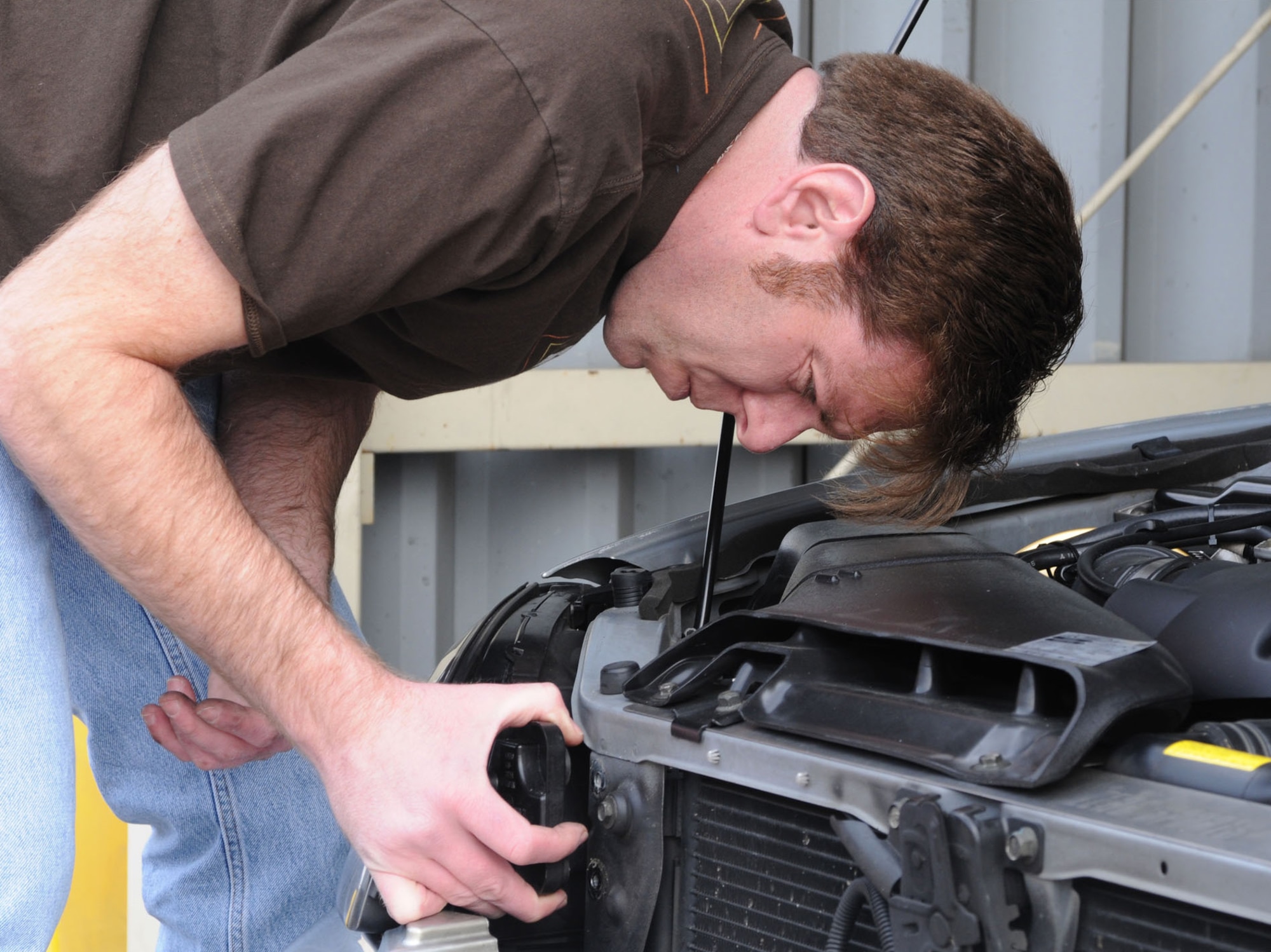 YOKOTA AIR BASE, Japan -- Larry Atkinson, 374th Civil Engineer Squadron Hazmat Pharmacy technician, changes a bulb in his car's headlight March 11 at the auto hobby center. (U.S. Air Force photo/Airman Devin Doskey)