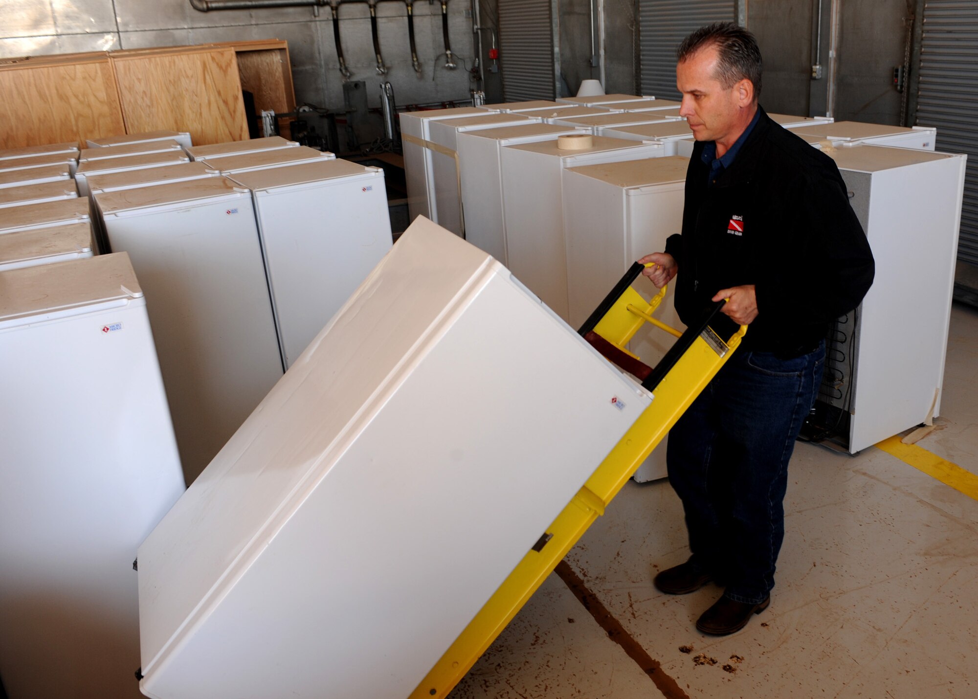 CANNON AIR FORCE BASE, N.M. -- Steve Myers, the base resource efficiency manager here, moves a refrigerator around a storage facility. An energy mandate now requires that refrigerators, microwaves and coffee pots be removed from personal work areas. This is not to be confused with office break areas. Individuals and units needing to turn in these items should e-mail steven.meyers@cannon.af.mil as soon as possible. A time will be scheduled for pick up. For any questions call (575) 784-0349. (U.S. Air Force photo/Airman 1st Class Evelyn Chavez)