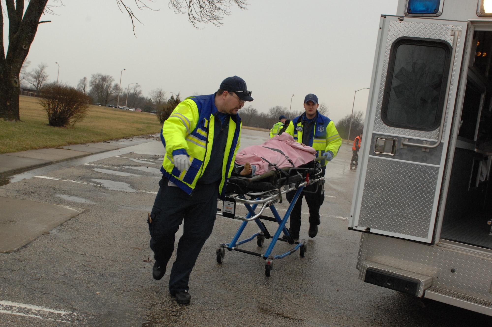 WHITEMAN AIR FOREC BASE, Mo. - Members of the Johnson County Ambulance District rush a simulated tornado victim to their ambulance during a Major Accident Response Exercise here March 10. The MARE focused on natural disaster preparedness and response for Whiteman and local community emergency responders. (U.S. Air Force photo/Staff Sgt. Charles Larkin)