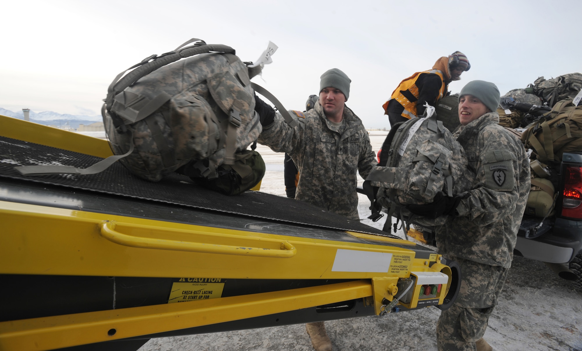 ELMENDORF AIR FORCE BASE, Alaska -- Army Spcs. Nathan Itle and Kevin Hayslit assist the 732nd Air Mobility Squadron ground crew in stacking bags on the contracted airliner, which is transporting their unit, 2377th P4 Alpha Battery, to Iraq March 10, 2009. Itle and Hayslit are apart of the unit's deployment transition team sent to help 732th AMS in getting their unit ready to deploy. (U.S. Air Force photo/ Senior Airman Matthew Owens)