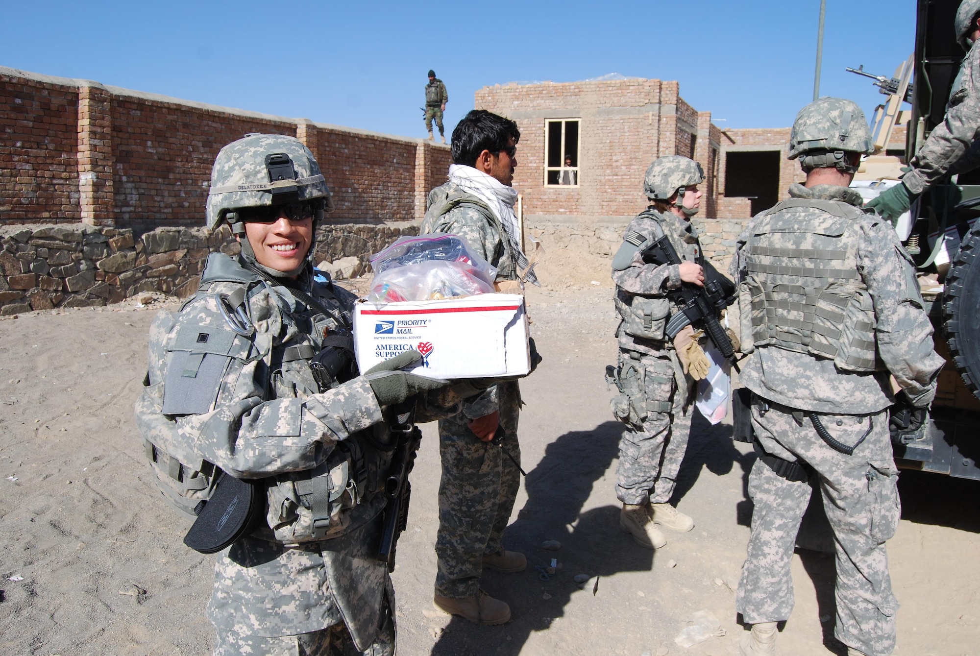 Maj. Diana Delatorre (center), an electronic warfare officer with the 2d Bomb Wing currently deployed to Gardez, Afghanistan, poses for a group picture after bringing school supplies, soccor balls and candy to children in the Khaga Hassan School and Orphanage December 2008. (Courtesy photo)