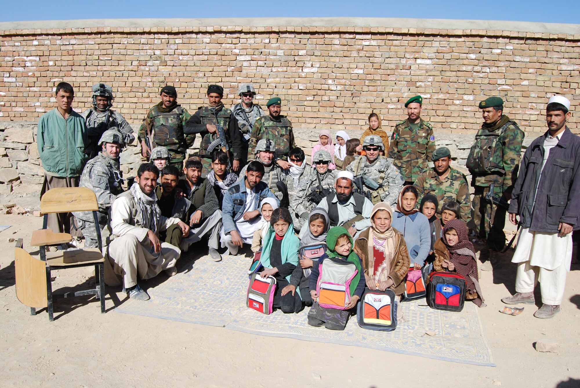 Maj. Diana Delatorre (center), an electronic warfare officer with the 2d Bomb Wing currently deployed to Gardez, Afghanistan, poses for a group picture after bringing school supplies, soccor balls and candy to children in the Khaga Hassan School and Orphanage December 2008. (Courtesy photo)