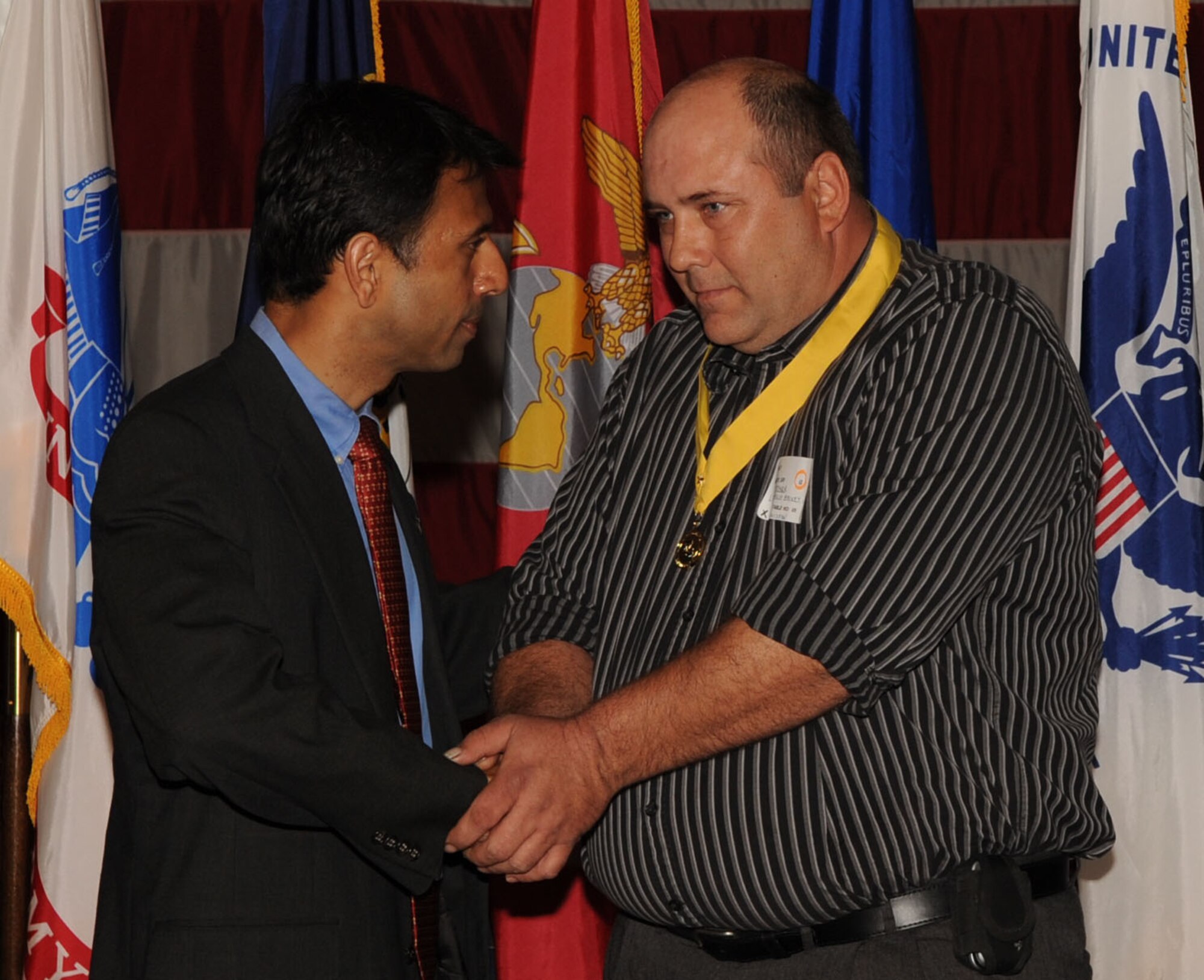 Louisiana Gov. Bobby Jindal shakes hands with a family member who lost a loved one in the war. (Senior Airman Alexandra Sandoval/U.S. Air Force ) 