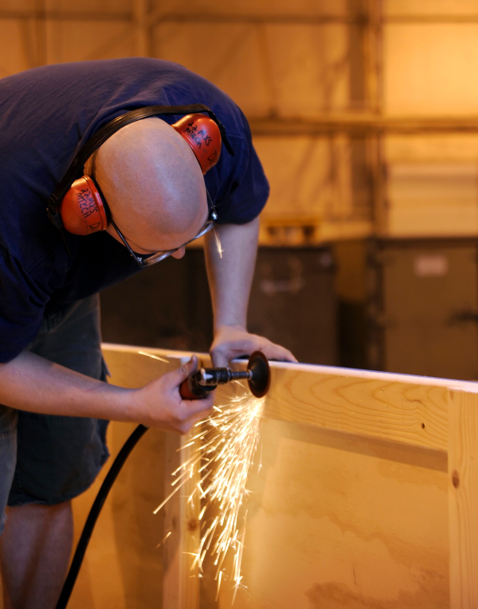 MCCONNELL AIR FORCE BASE, Kan. -- Senior Airman Richard Duffner, 22nd Maintenance Squadron, sands down nails on the new Team McConnell float in hanger 1111, Feb. 27. The float will make its debut at the St. Patrick’s Day parade held Saturday, March 14 in the Delano shopping district. (Photo by Senior Airman Laura Suttles)