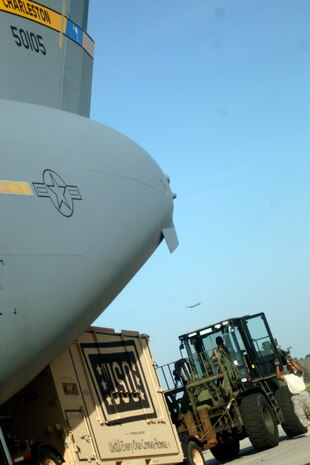 Senior Airman Raymond Banks guides a 10k all terrain forklift into position to load the USO's newest morale boosting program here March 8. This is the first USO in a Box to deployed service members downrange. Airman Banks is with the 437th Aerial Port Squadron. (U.S. Air Force photo/Senior Airman Timothy Taylor)