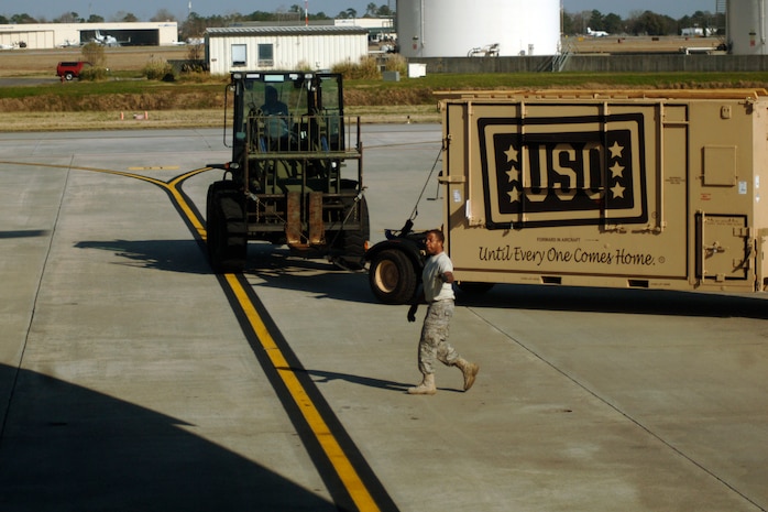 Senior Airman Raymond Banks guides a 10k all terrain forklift into position to load new USO boxes here March 8. The USO delivers its programs and services to 1.4 million active duty service members and 1.2 million National Guard and Reserves as well as their families at more than 130 centers worldwide. Airman Banks is with the 437th Aerial Port Squadron. (U.S. Air Force photo/Senior Airman Timothy Taylor)