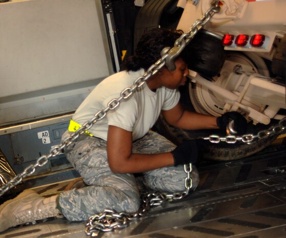 Senior Airman Veronica Garrison secures a USO cargo box to the floor of a Charleston C-17 here March 8. This is the first USO in a Box shipment to deployed service members downrange. Airman Garrison is with the 437th Aerial Port Squadron. (U.S. Air Force photo/Senior Airman Timothy Taylor)